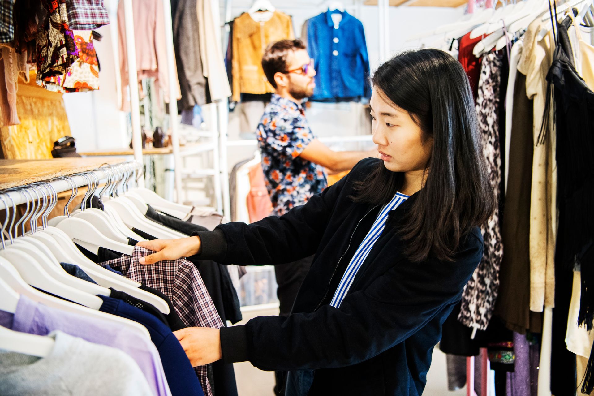 A woman browsing clothes in a vintage shop.