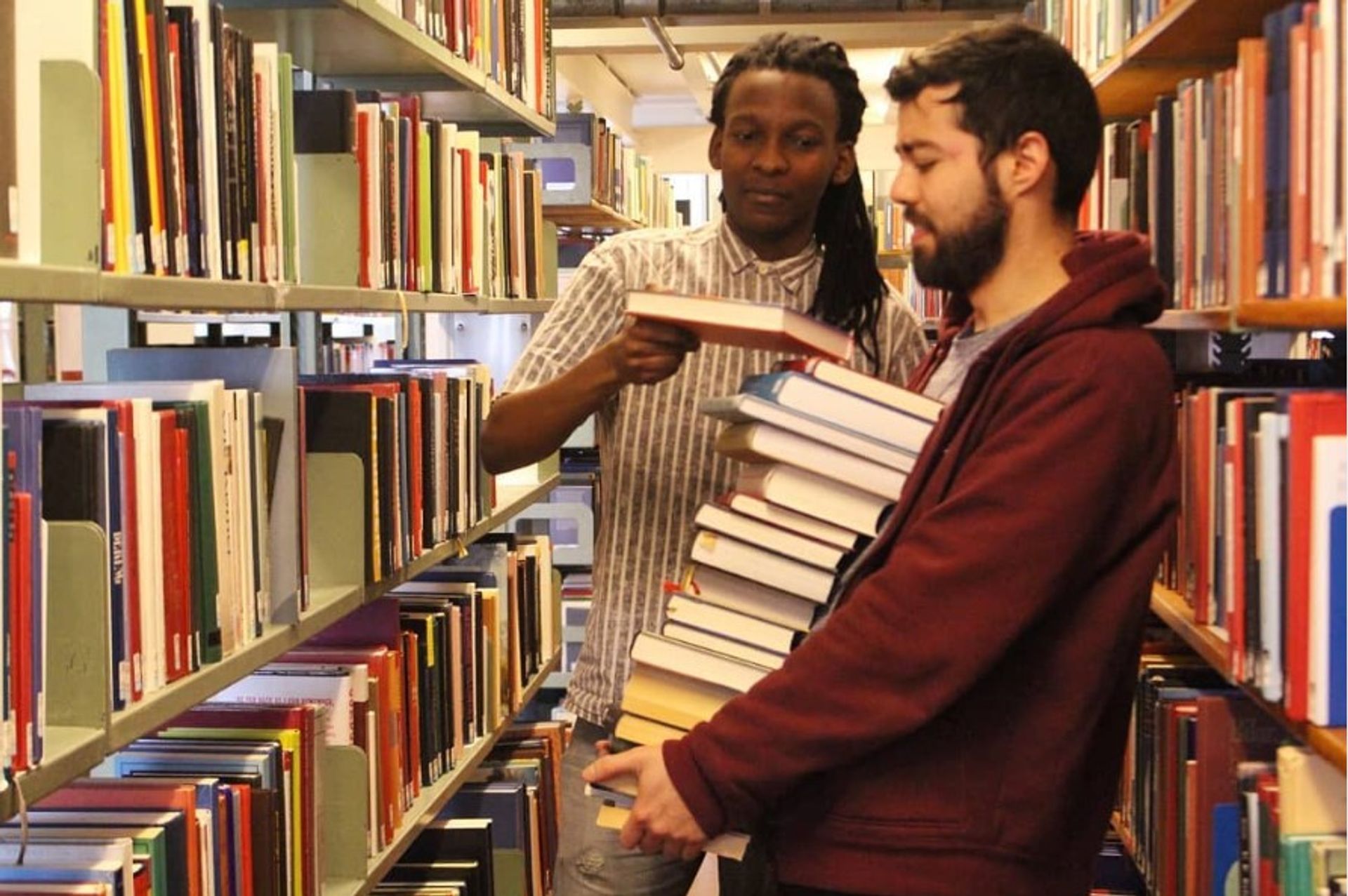 Two students taking library books out of the library.