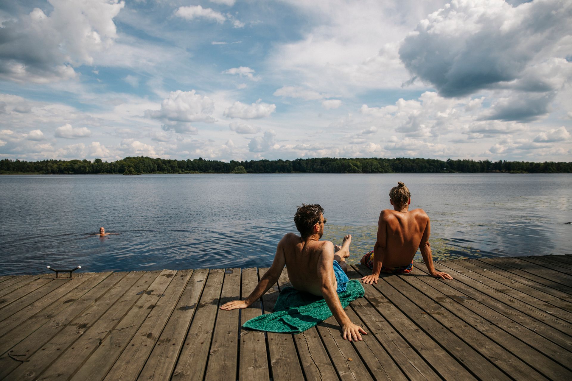 By the lake , two men tanning