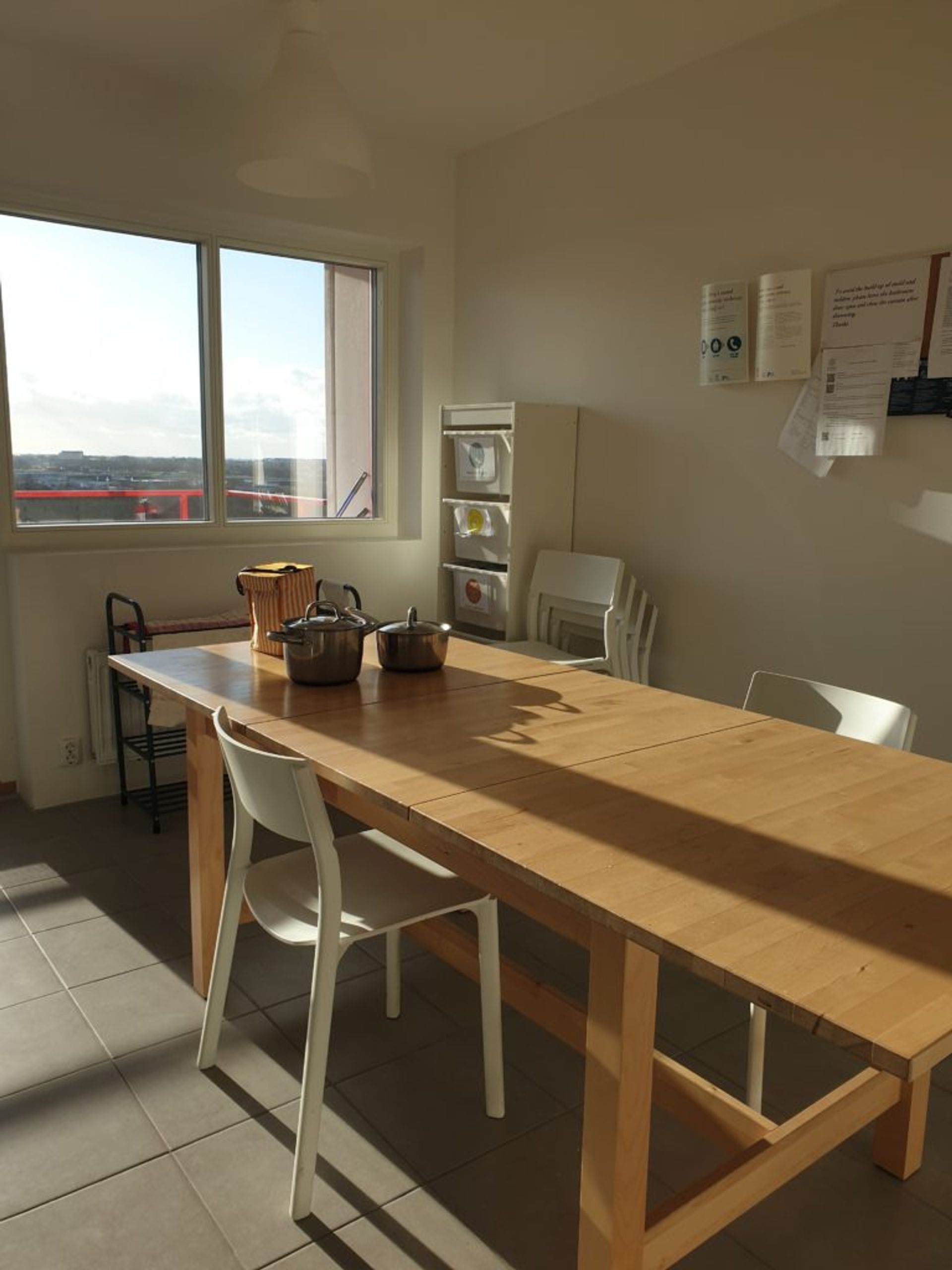 Wood table with white chairs with sun shining through window