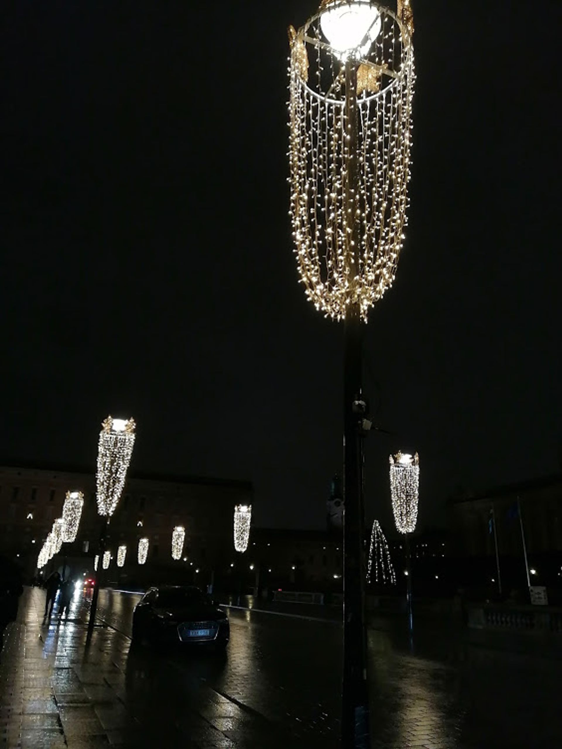 Hanging fairy lights on a row of streetlamps