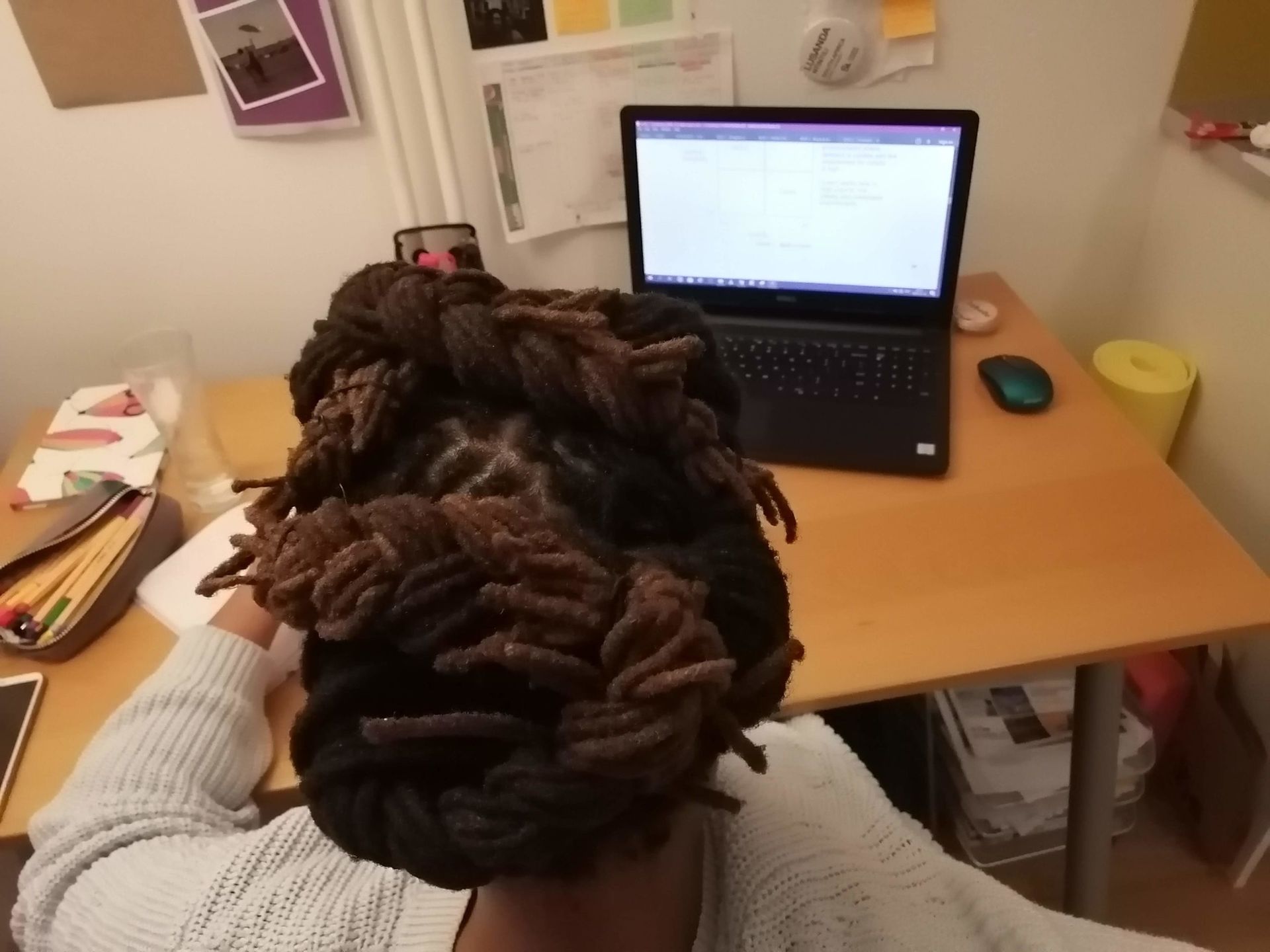 A woman sitting in front of a desk and a laptop