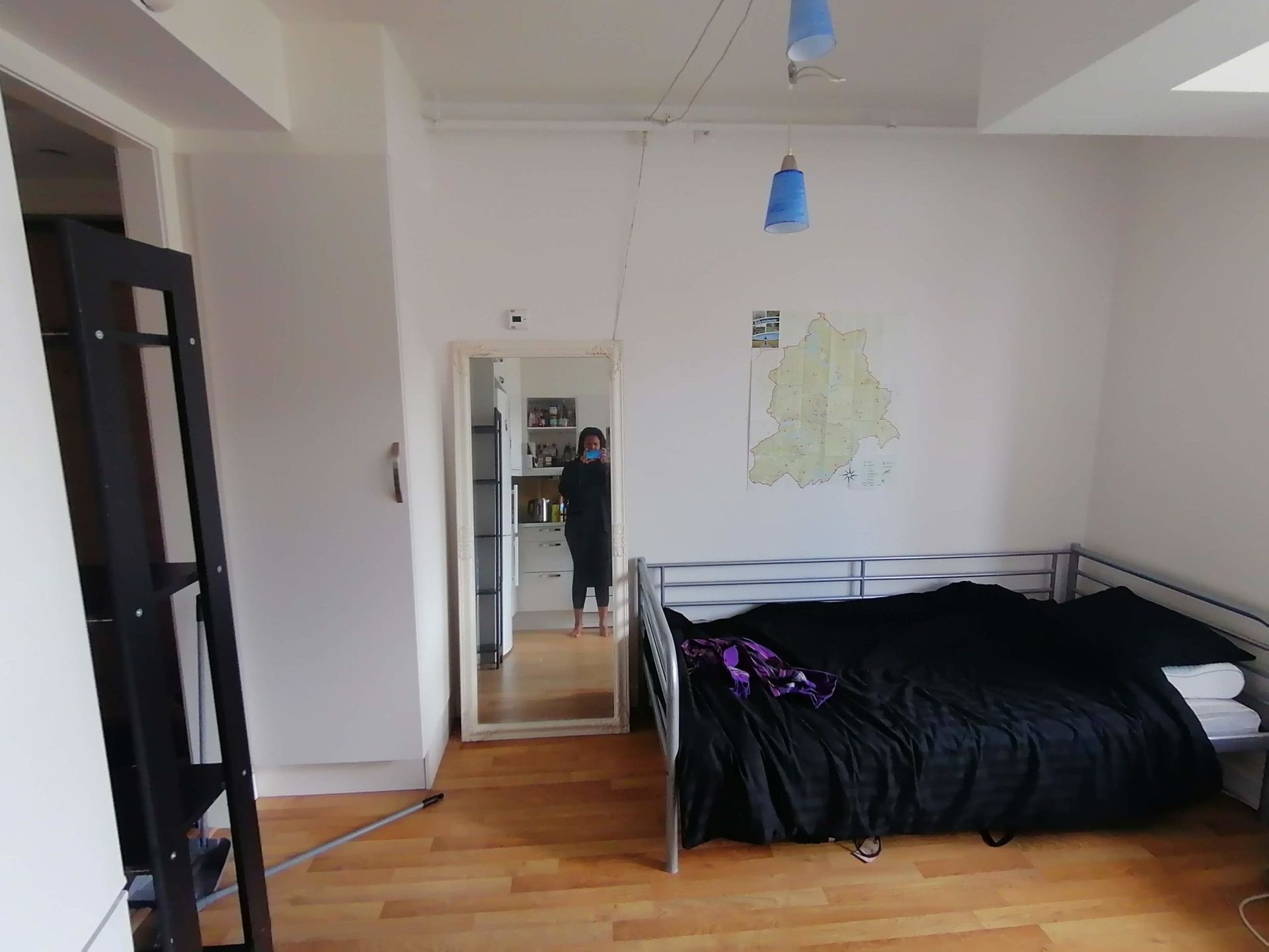 A mirror next to a bed in an aparment