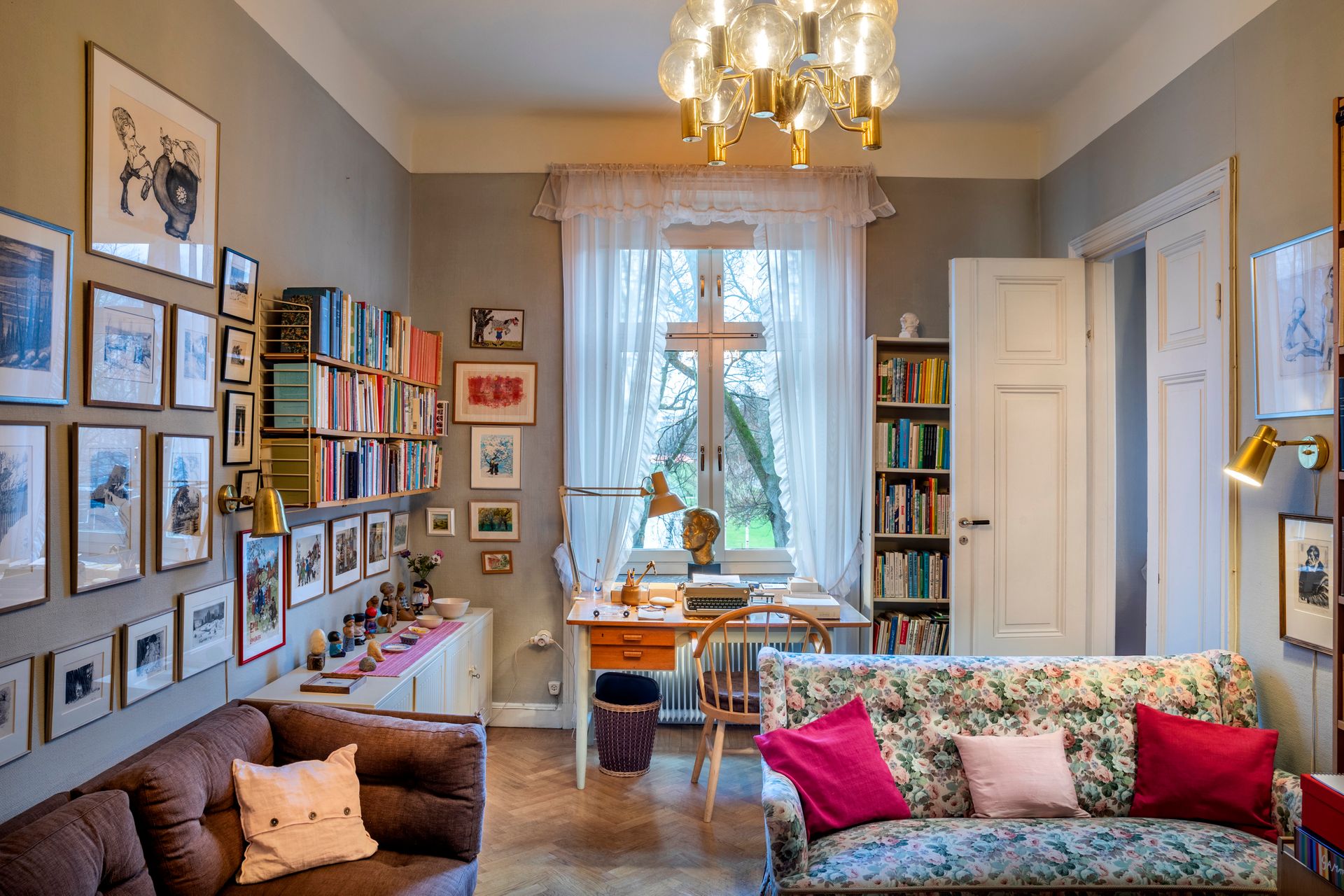 A cozy flat with bookshelf, posters, and a big window 