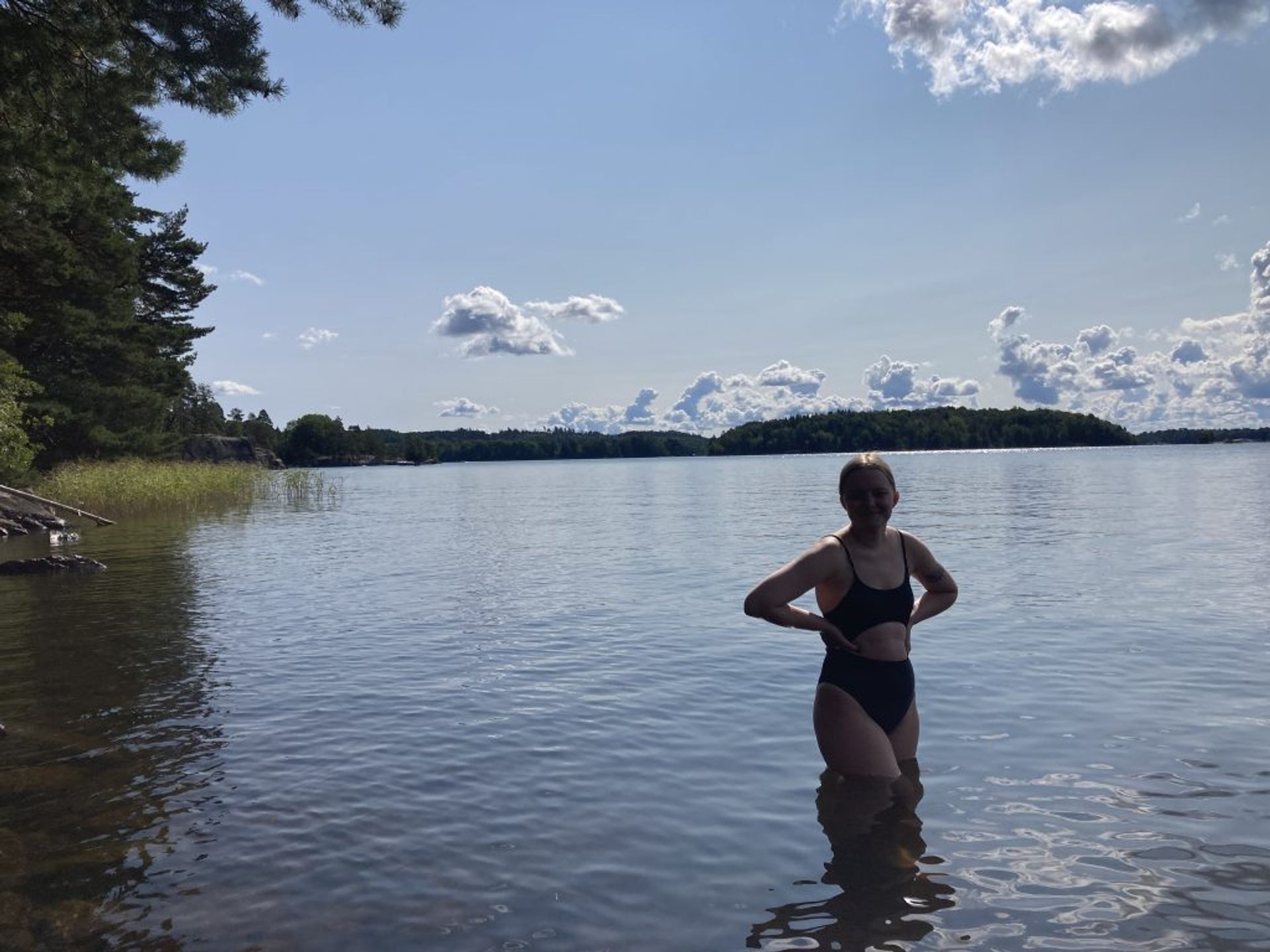 Brooke standing in a lake, submerged up to her knees.