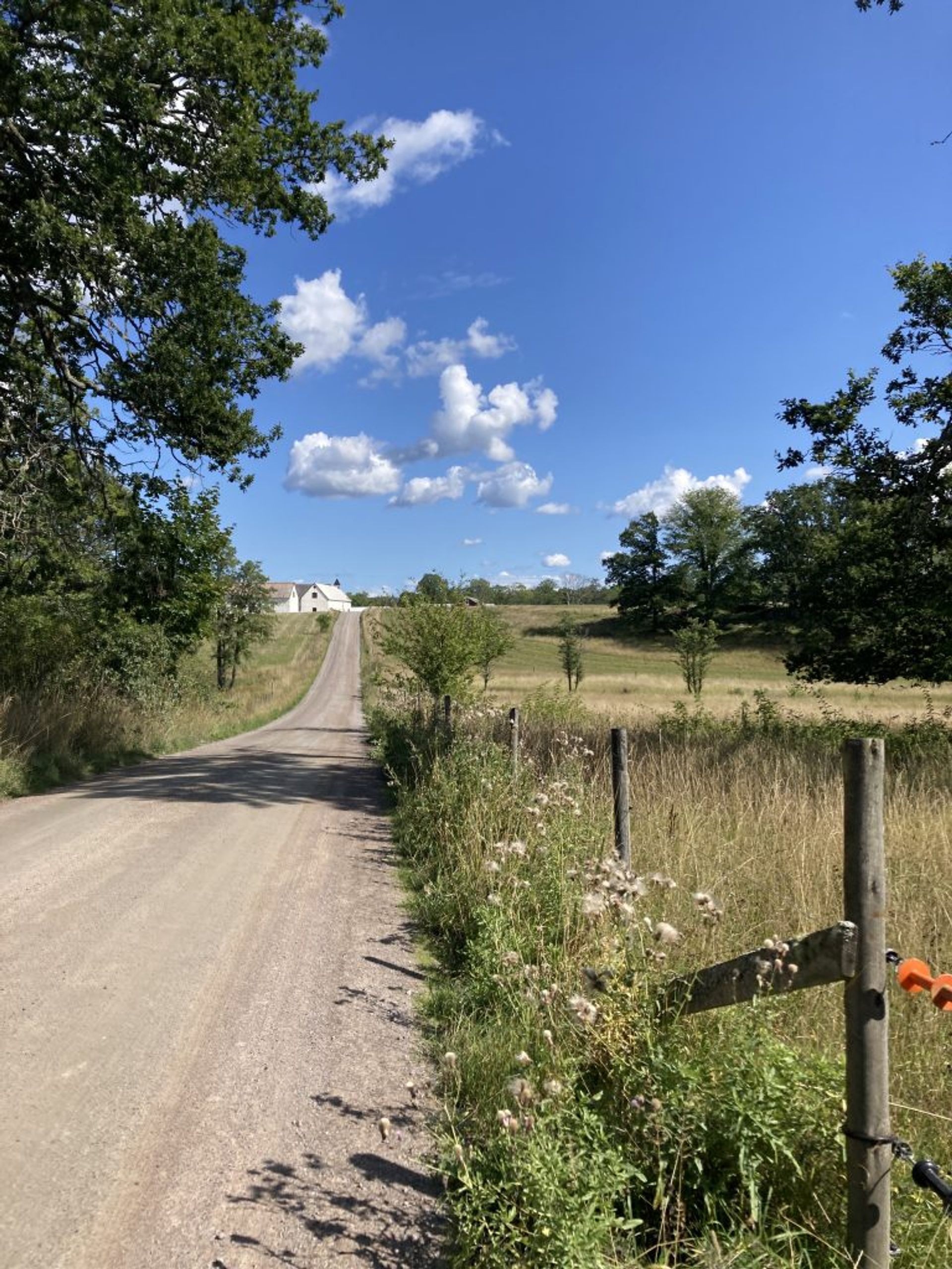 A long road with meadows on either side.