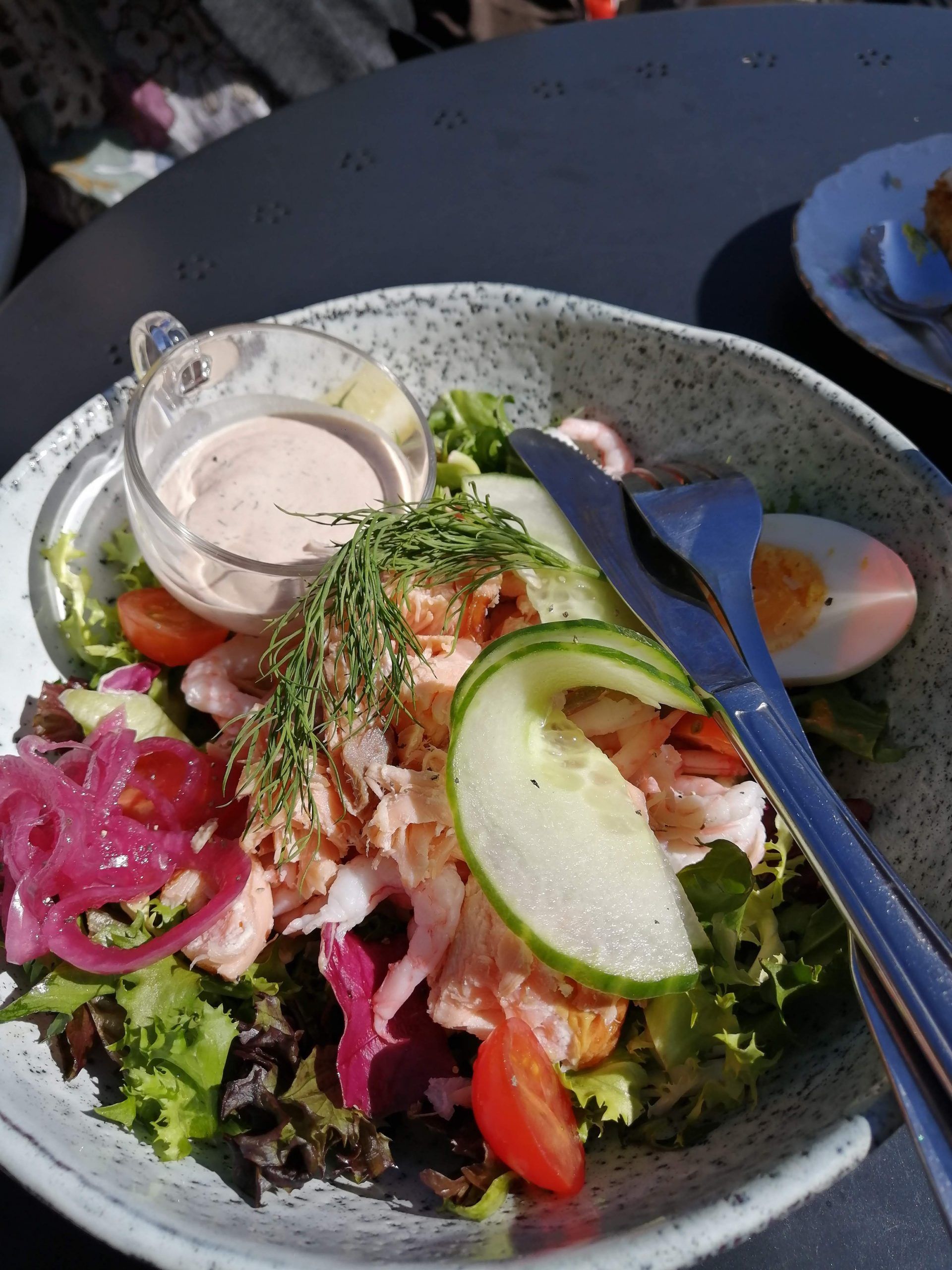 A prawn, cucumber and pickled red onion salad on mixed leaves
