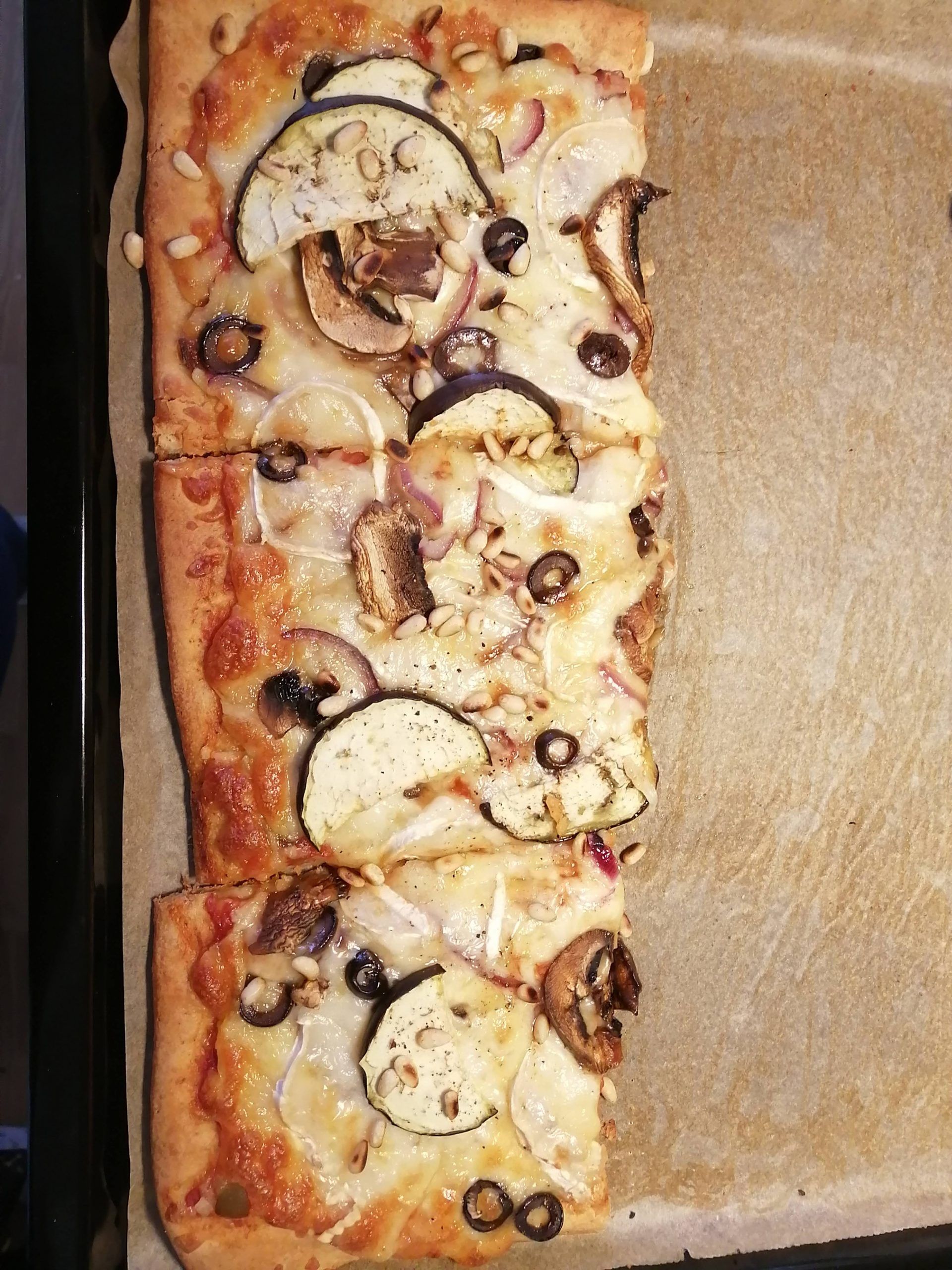 Leftover homemade pizza slices with eggplant, pine nute and red onion