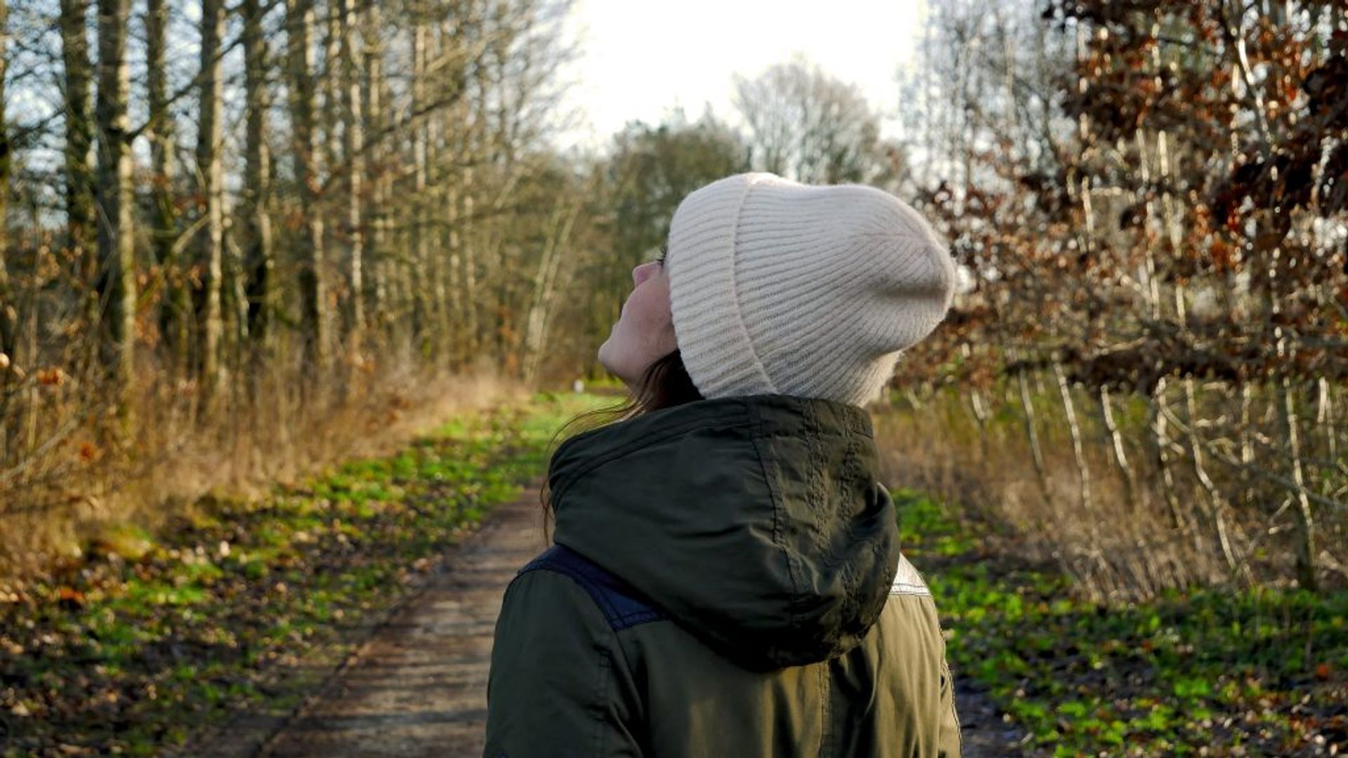 A girl with  white hat walking a forest in autumn. 