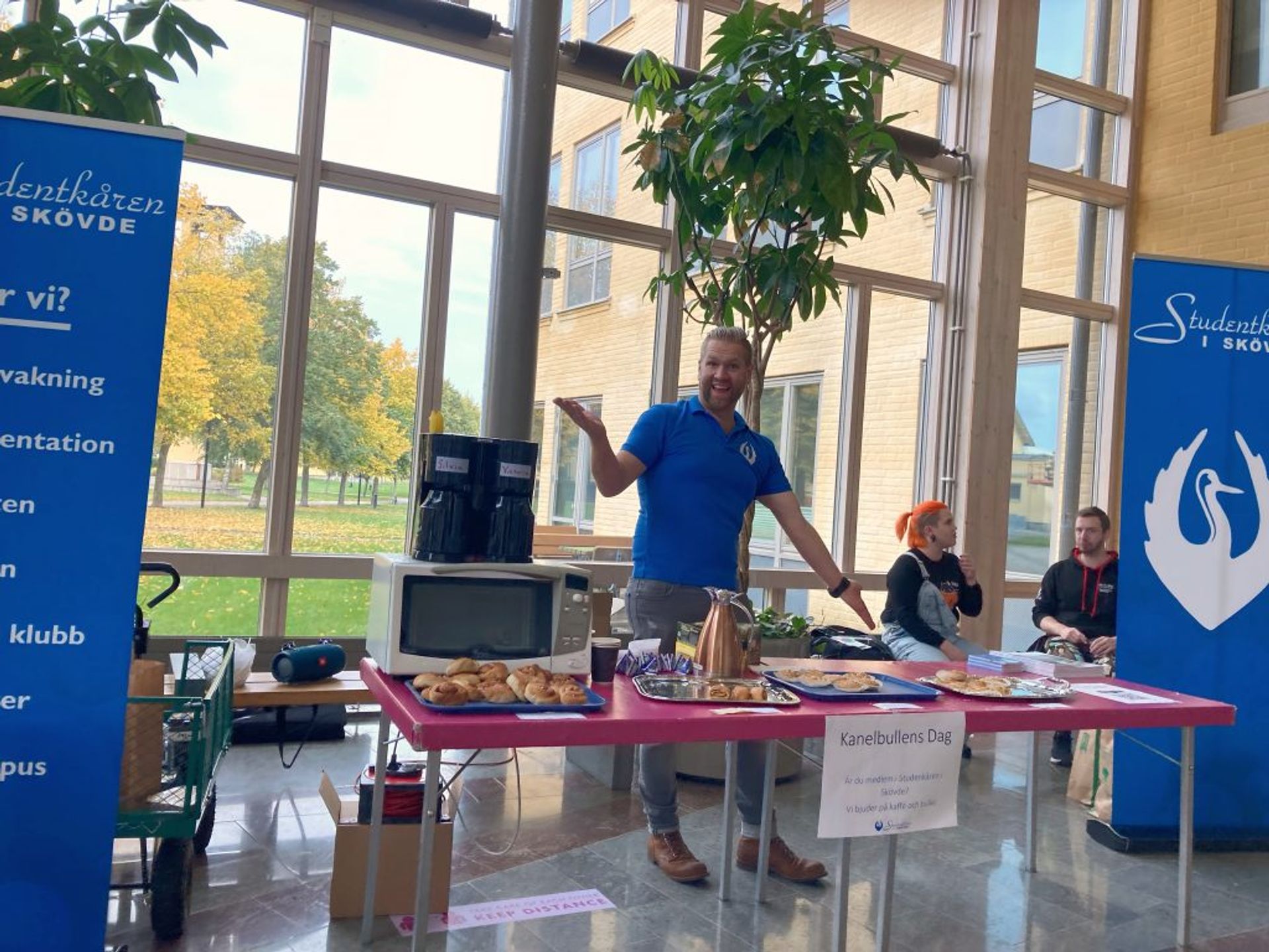 People offering free cinnamon rolls at the University of Skövde.