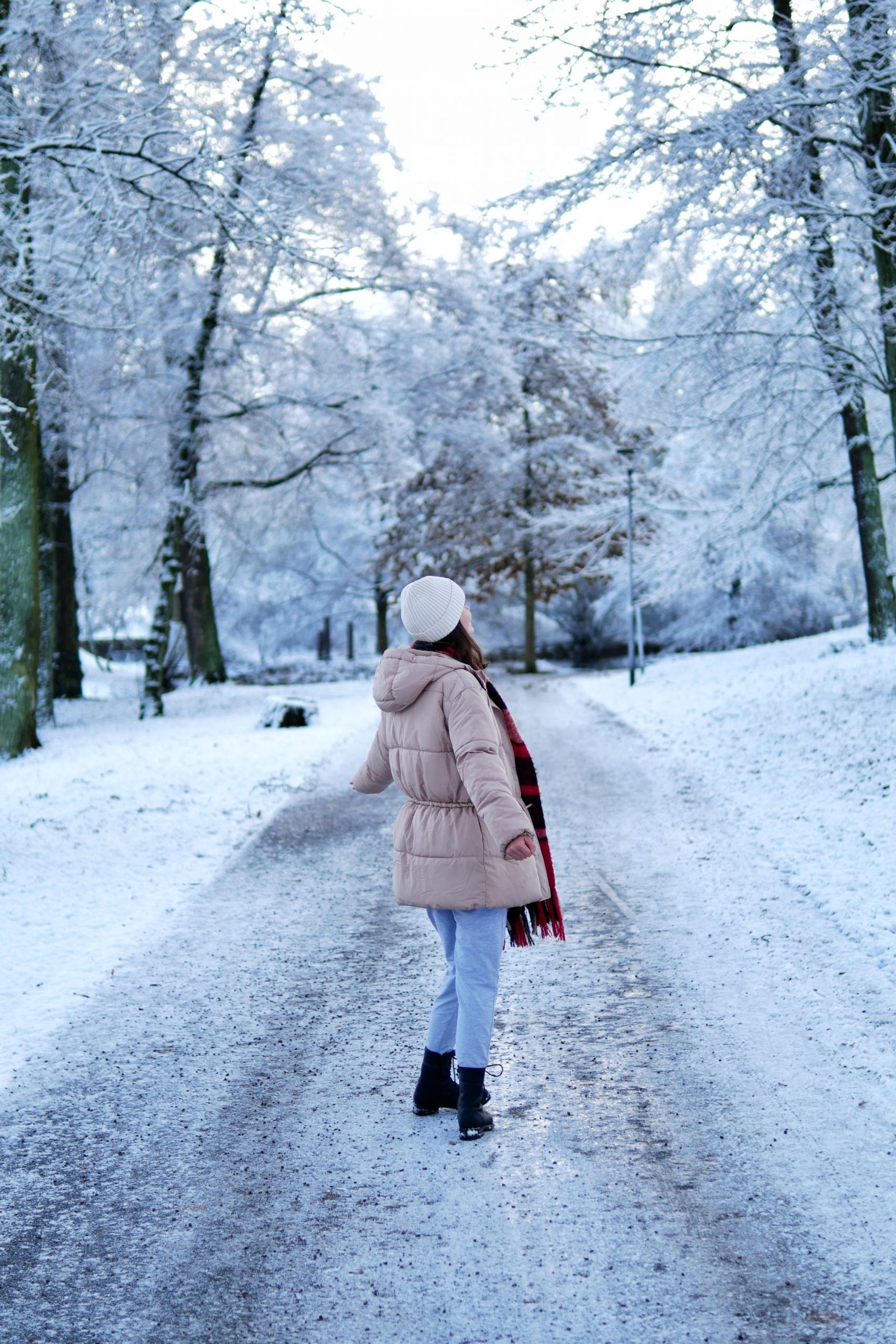 A girl facing away from the camera in a snowy park