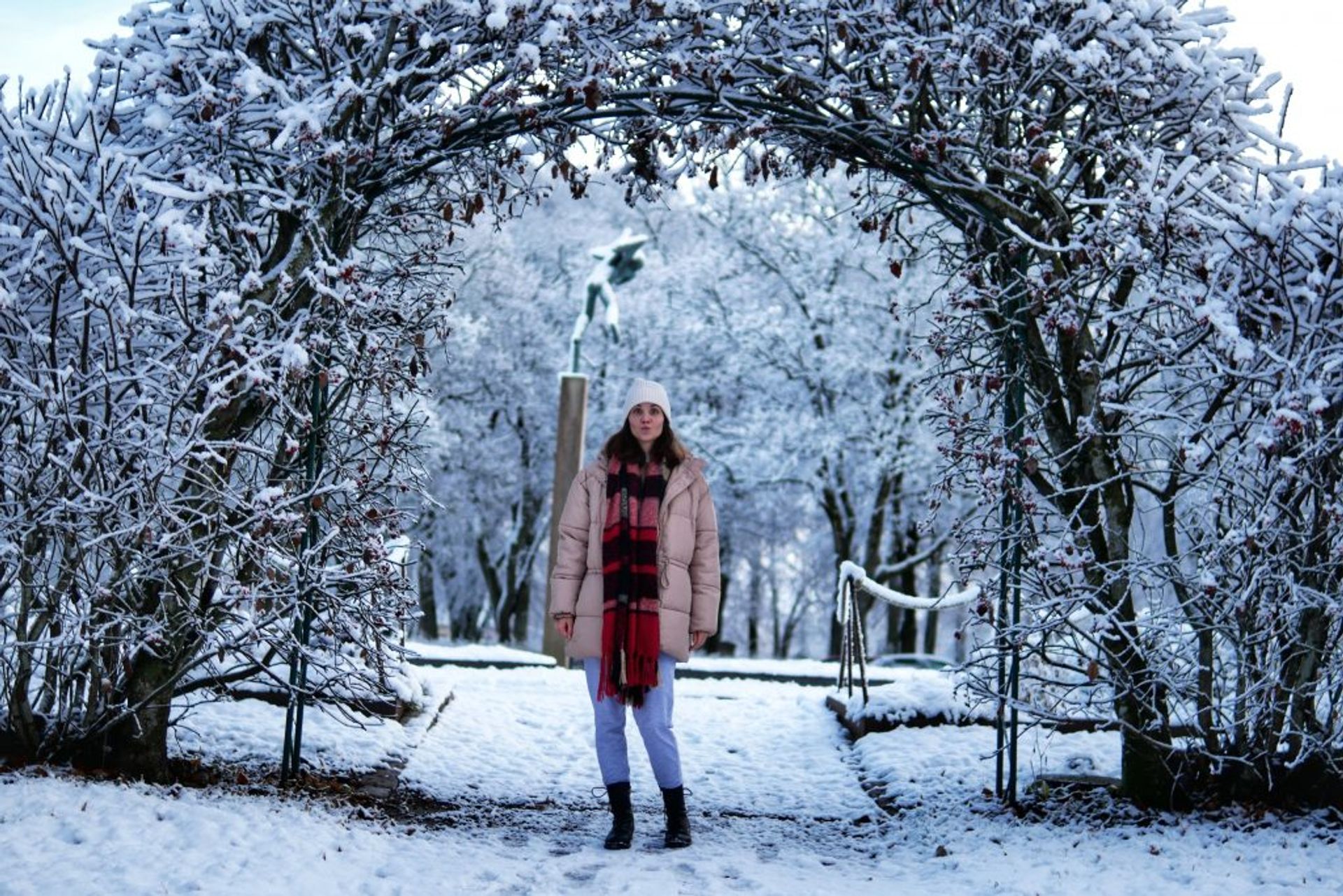 A girl in a winter jacket posing for a photo with a funny face. 