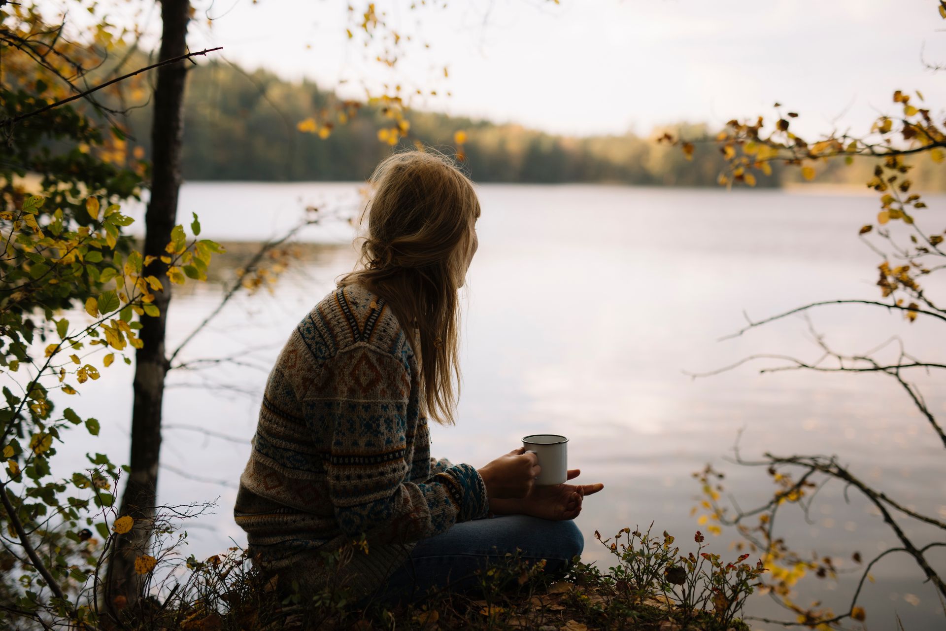 A girl having fika by a lake