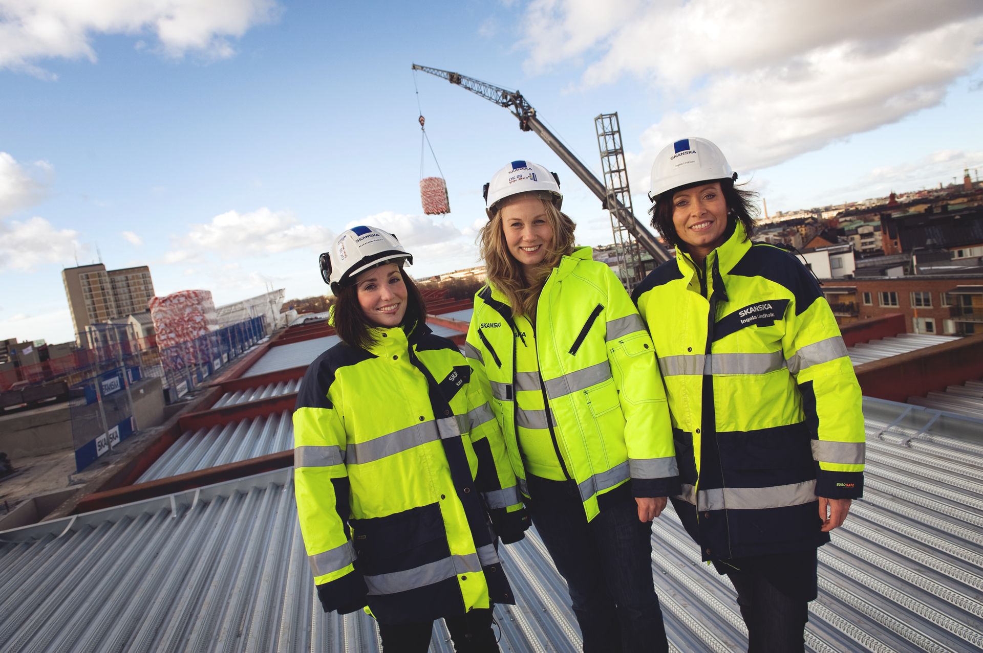 Three young women at a construction site. 