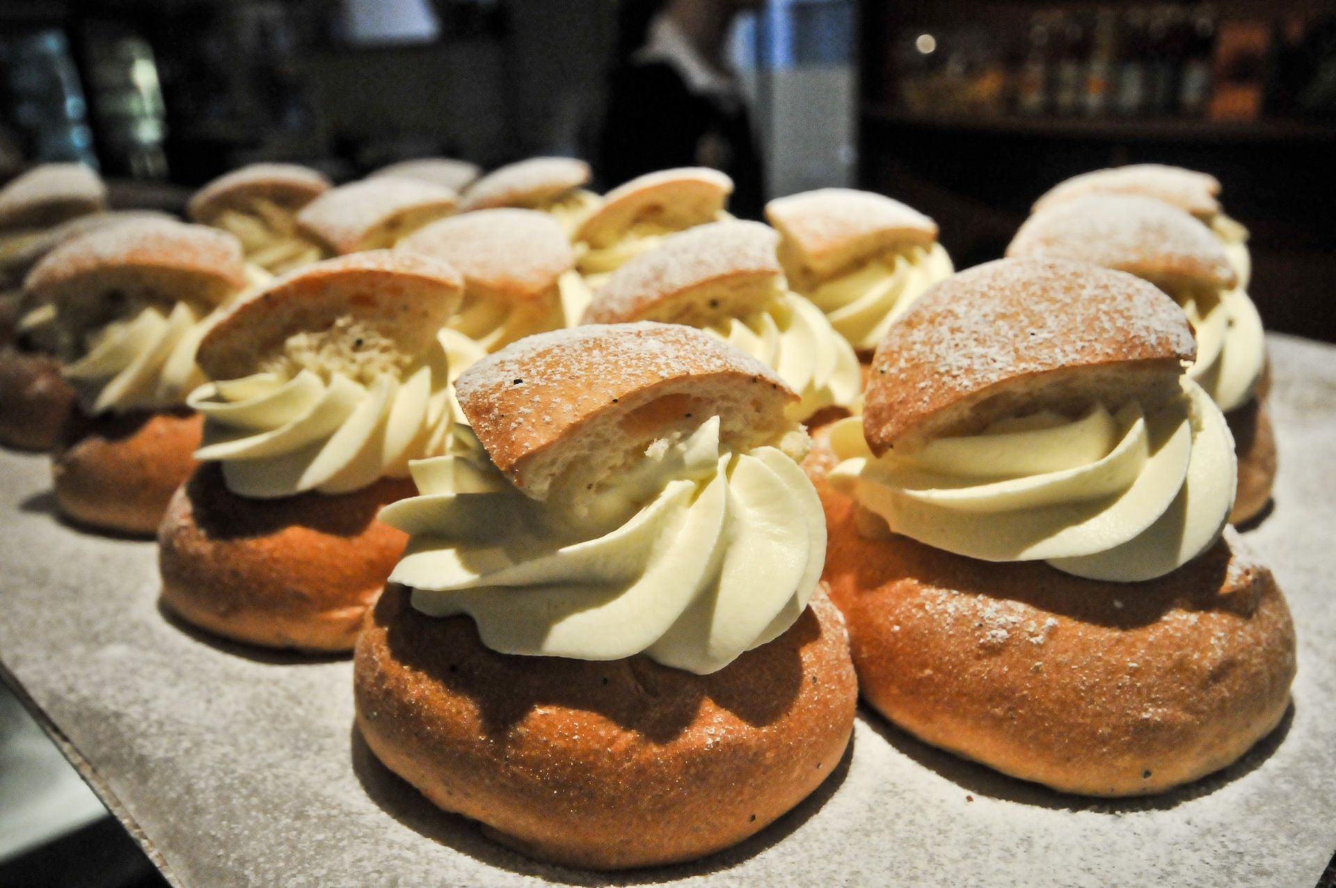 A close up of some cardamon buns (called Semlor in Swedish). A bun with almond paste and whipped cream.