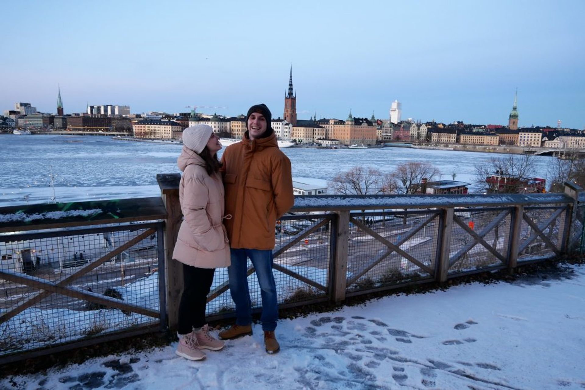 A couple (man and woman) laughing with Stockholm in the background. 