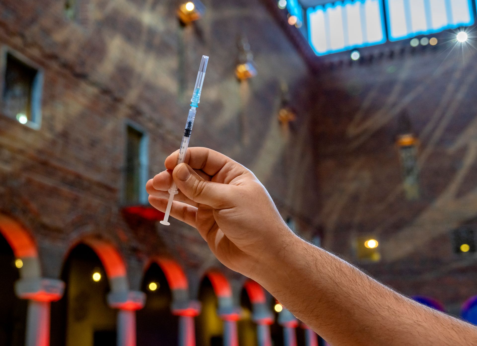 A hand holding a syringe.