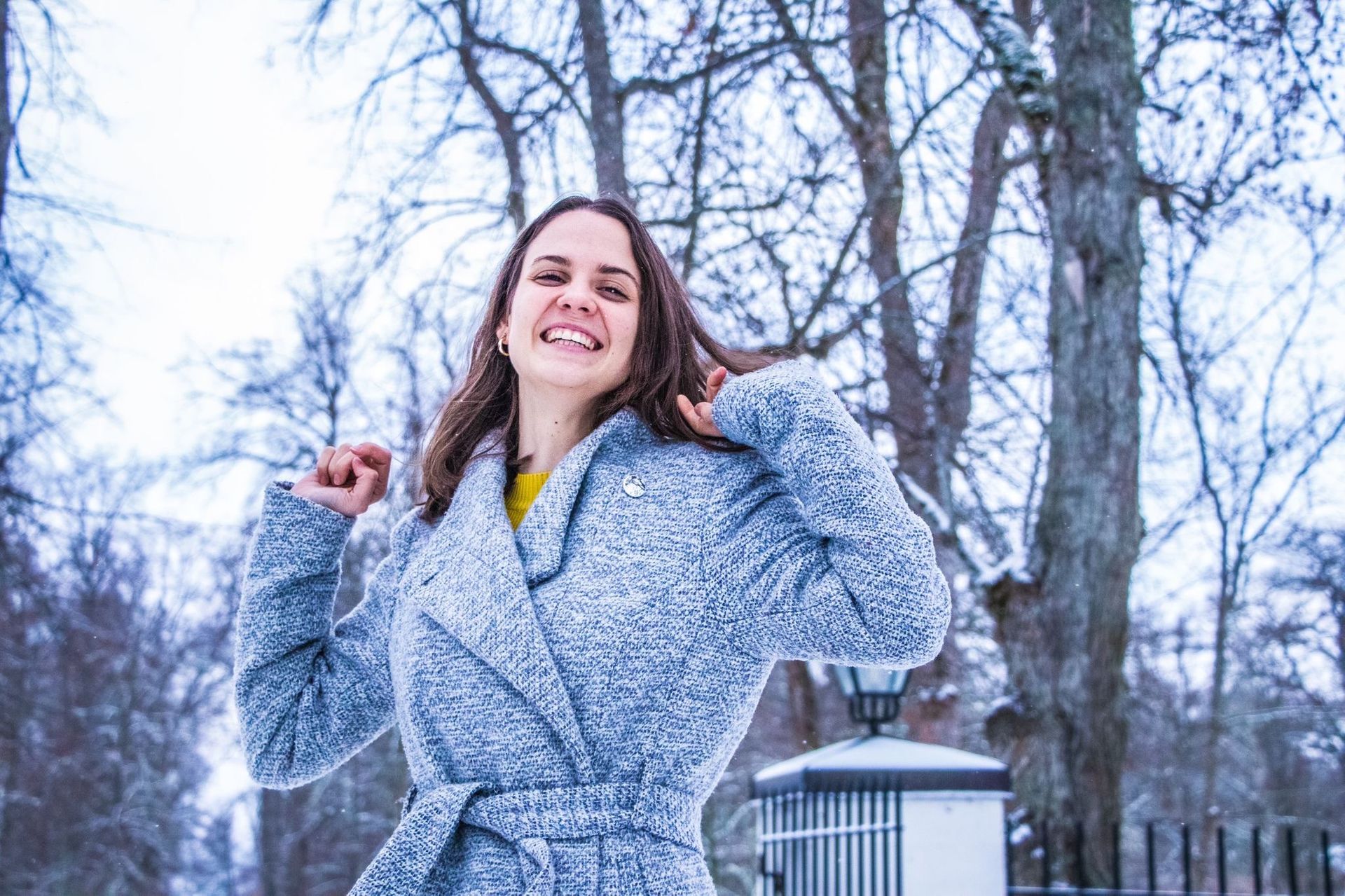 A girls in a coat smiling.