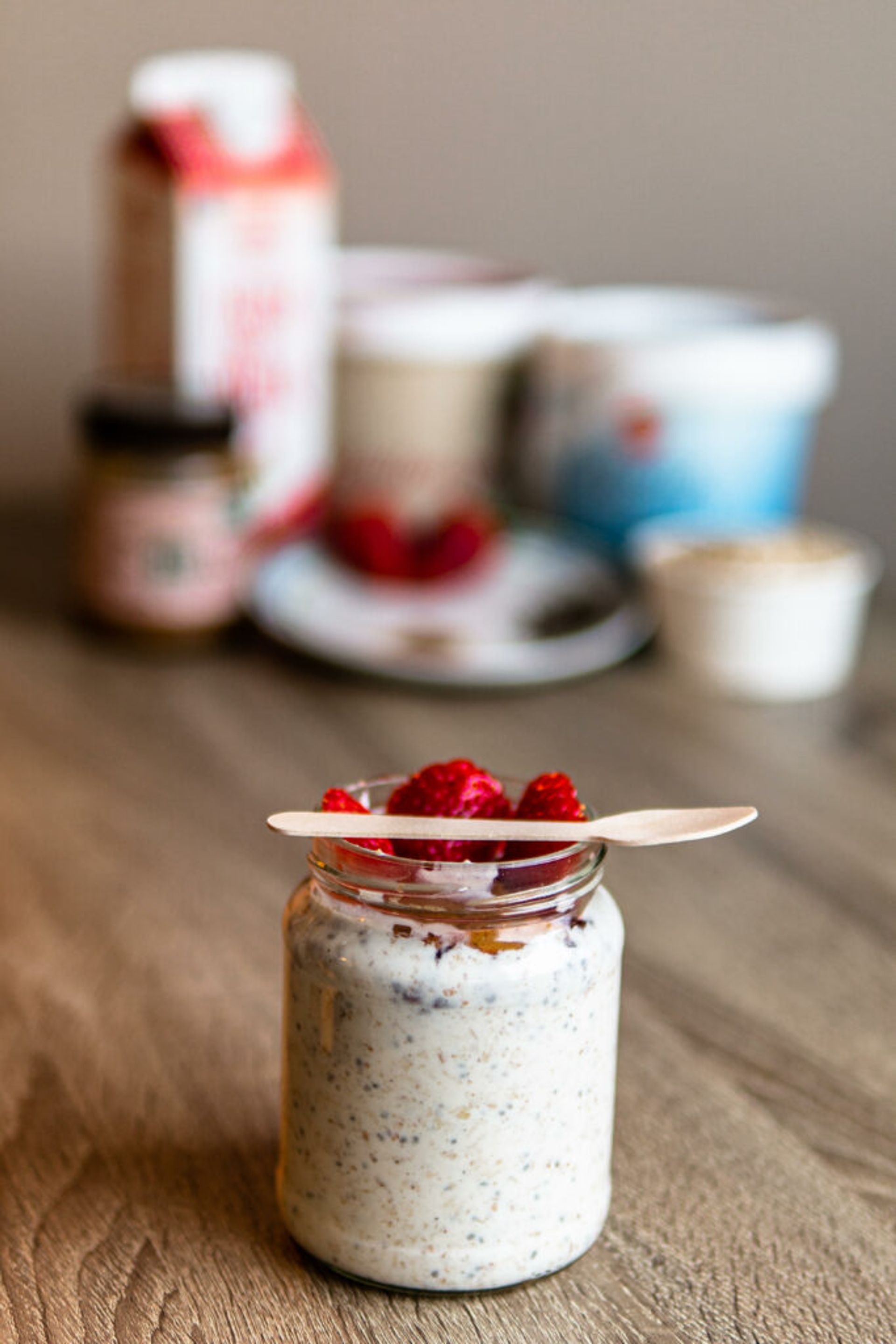 Overnight oats in a jar with strawberries and small spoon on top. 