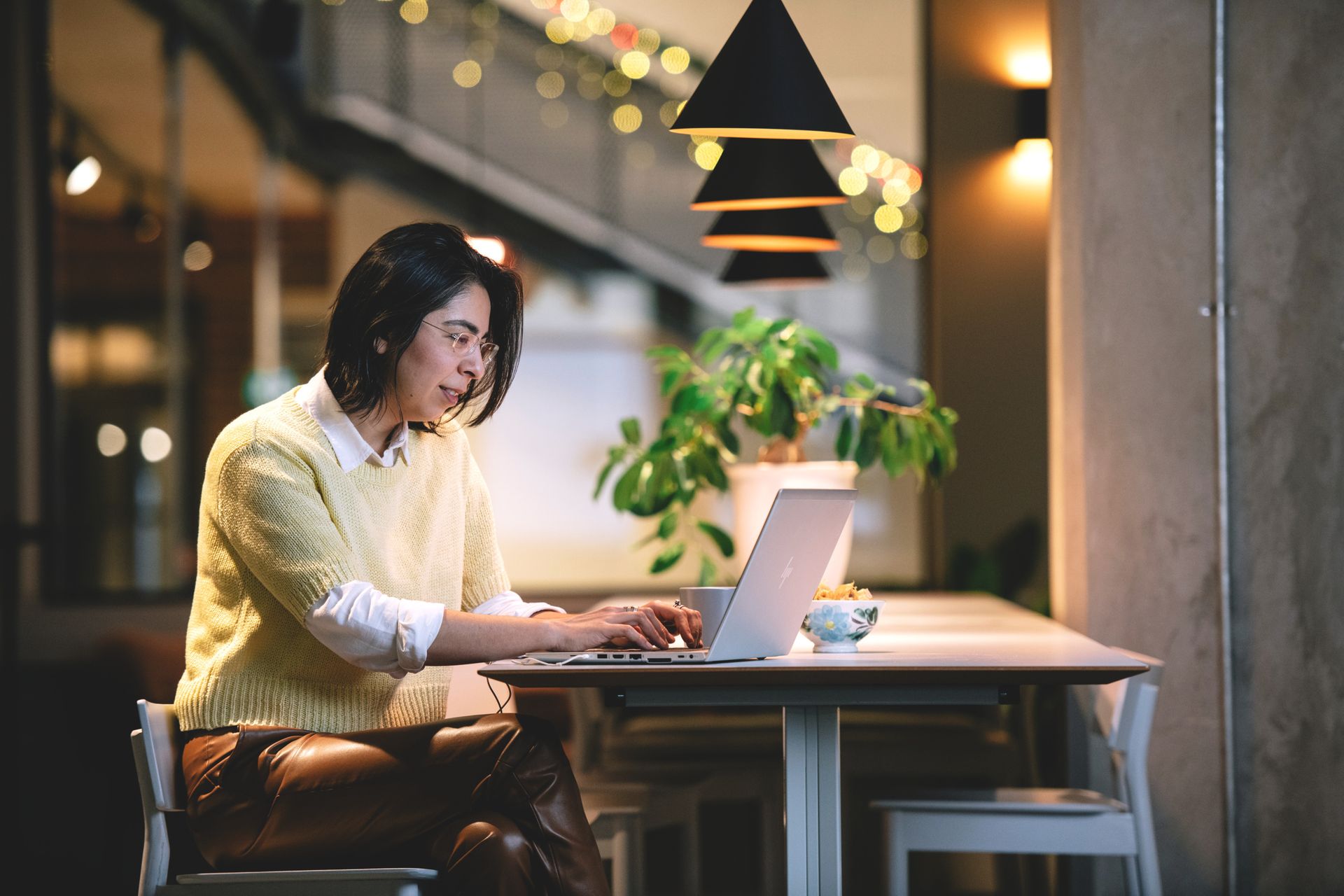 A woman sits at a desk with a computer.