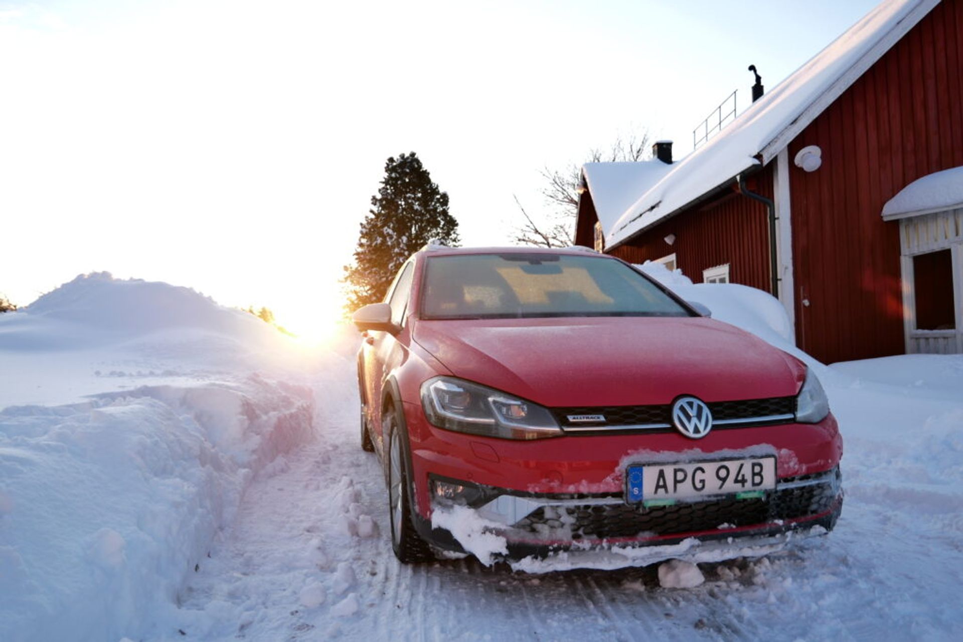 A red car in a snowy environment. 