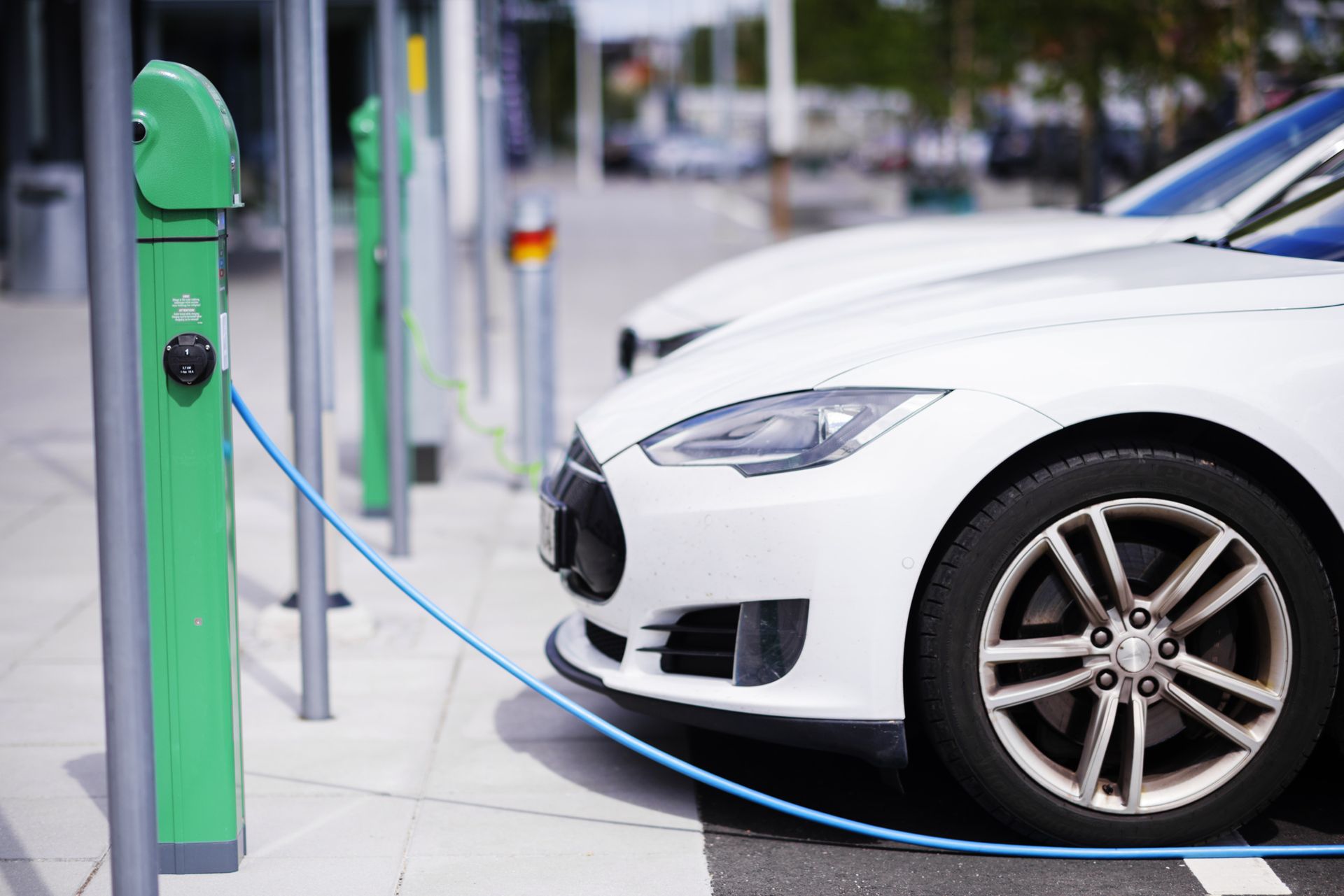 White electric car at a charging station.