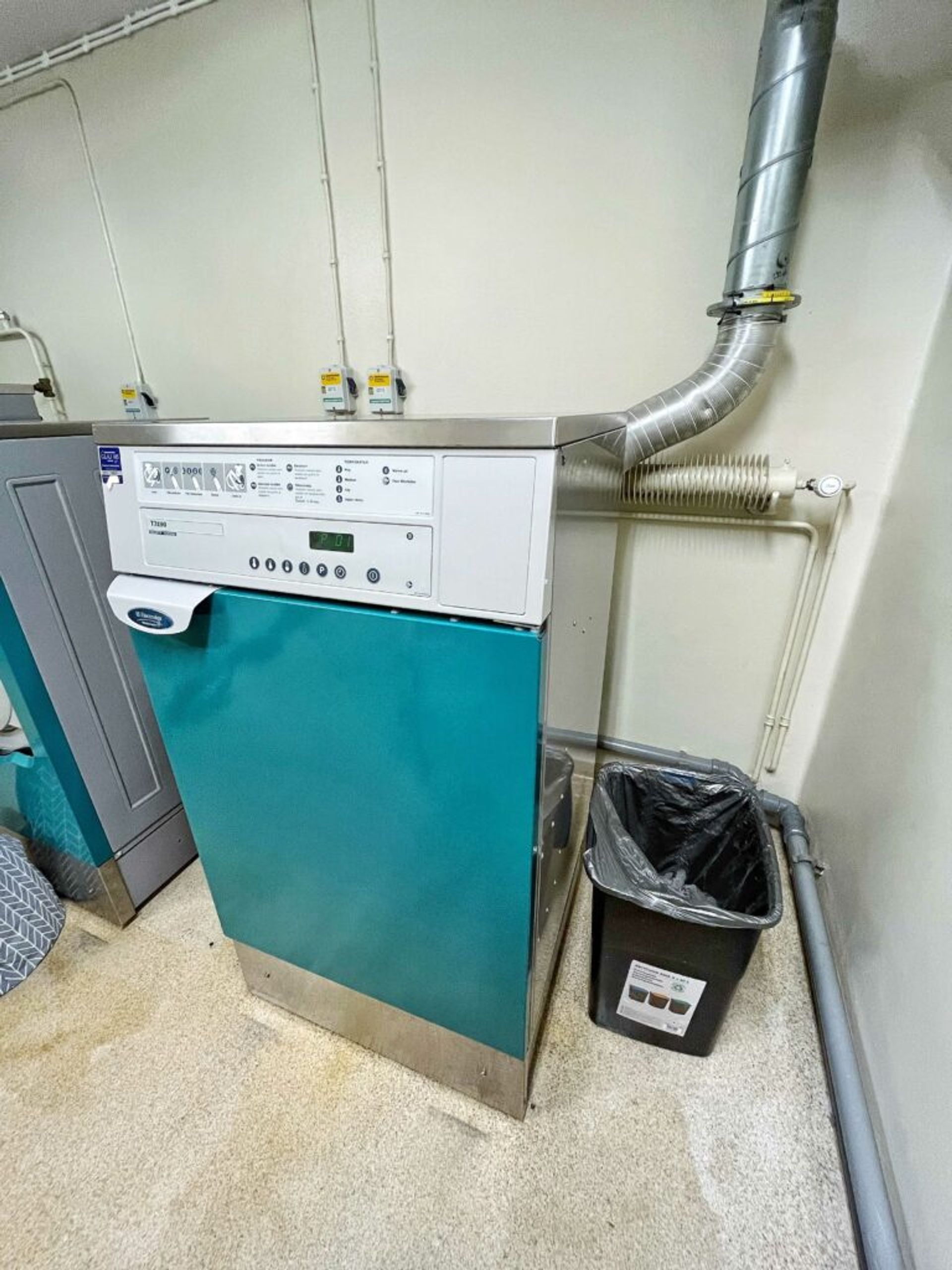 A dryer and trash can.