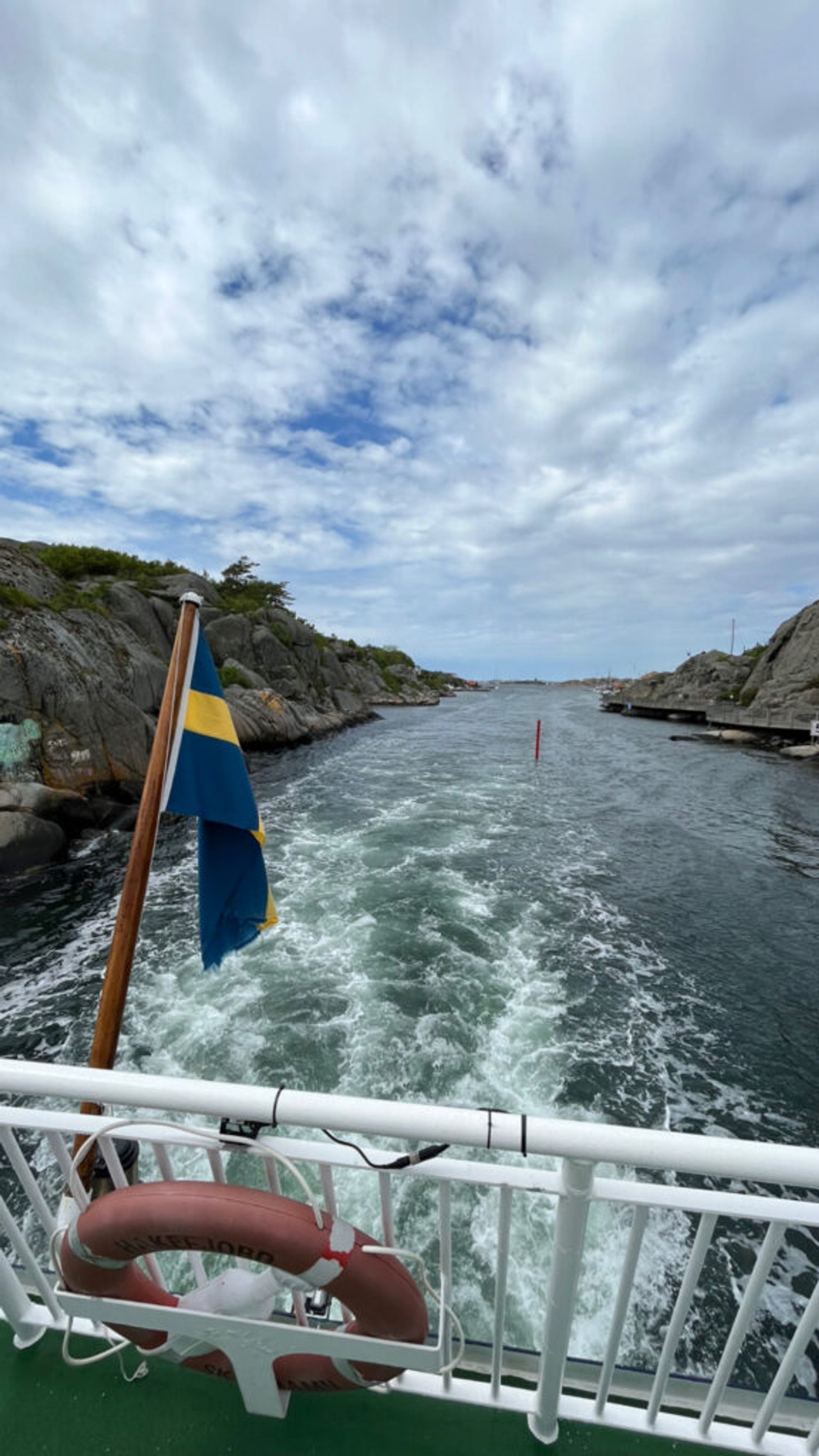 A rear view from a ferry sailing on the water.