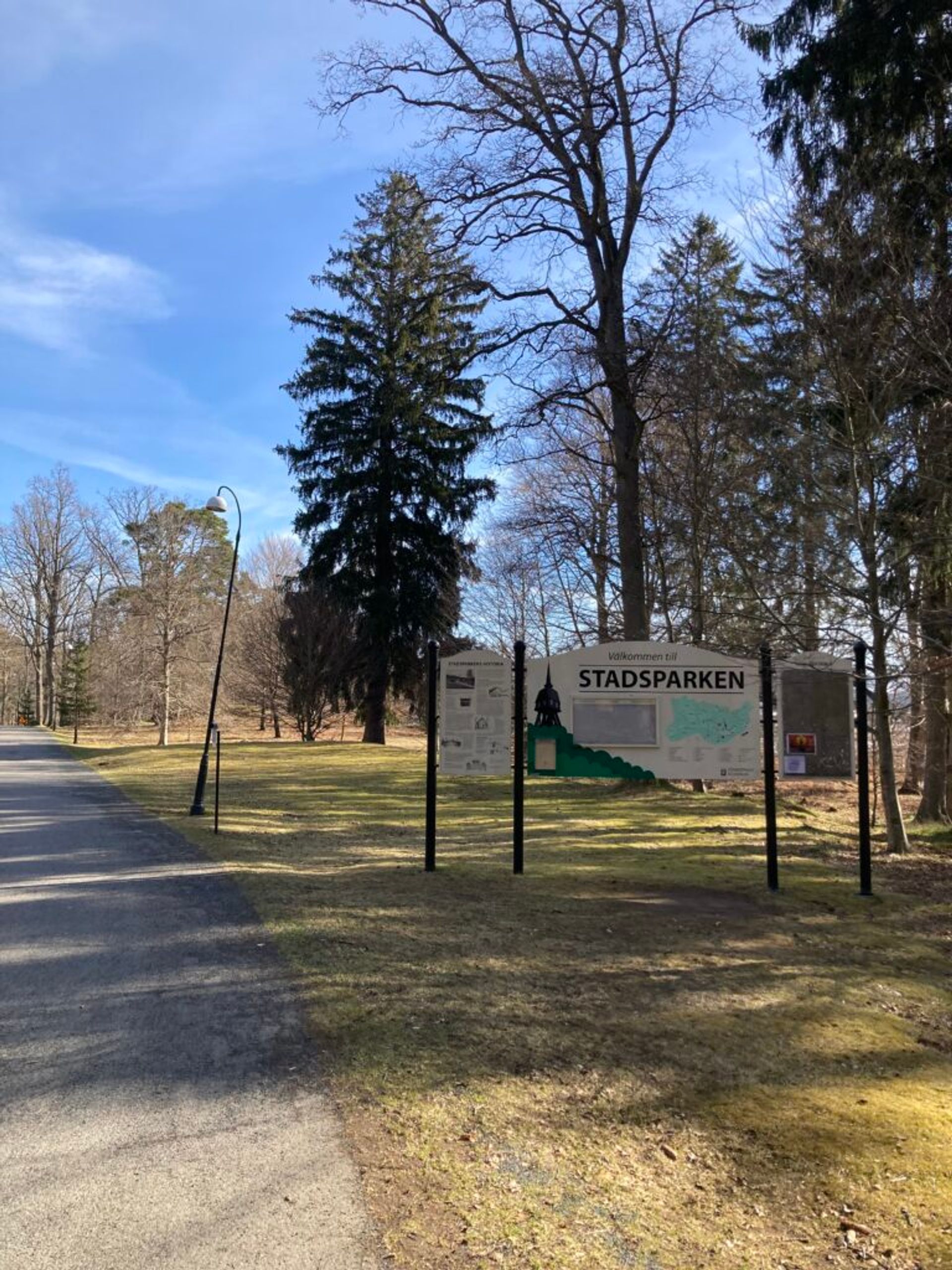 Park entrance with a map display set against a backdrop of trees.