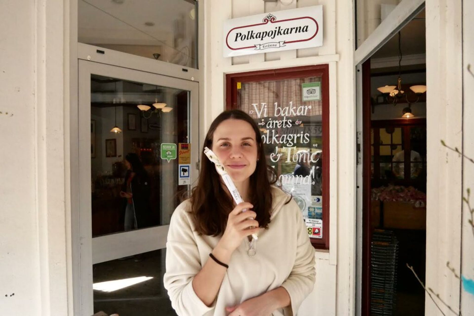 A woman standing in front of an old-fashioned candy shop.