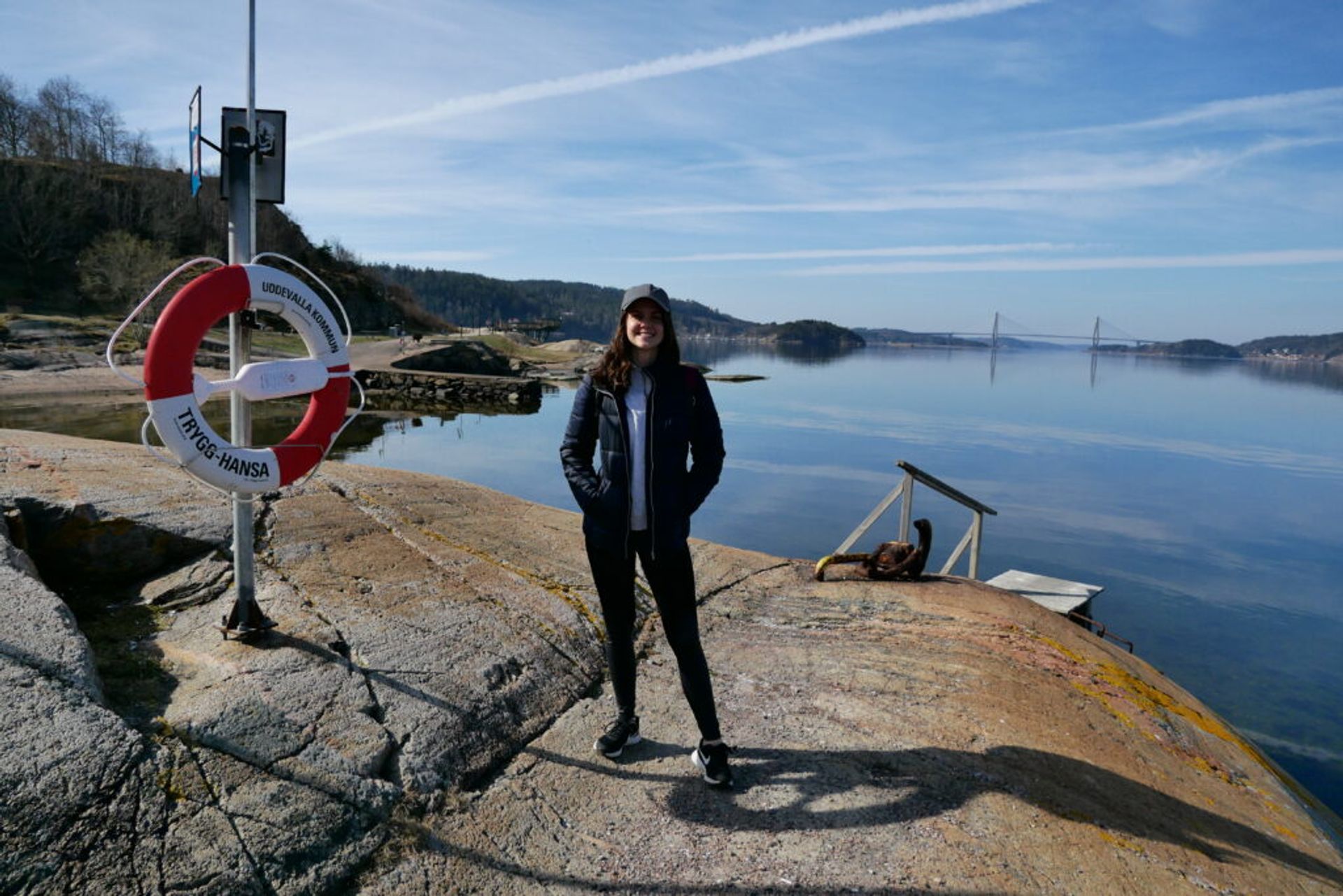 A person standing by the water's edge, smiling for the camera.