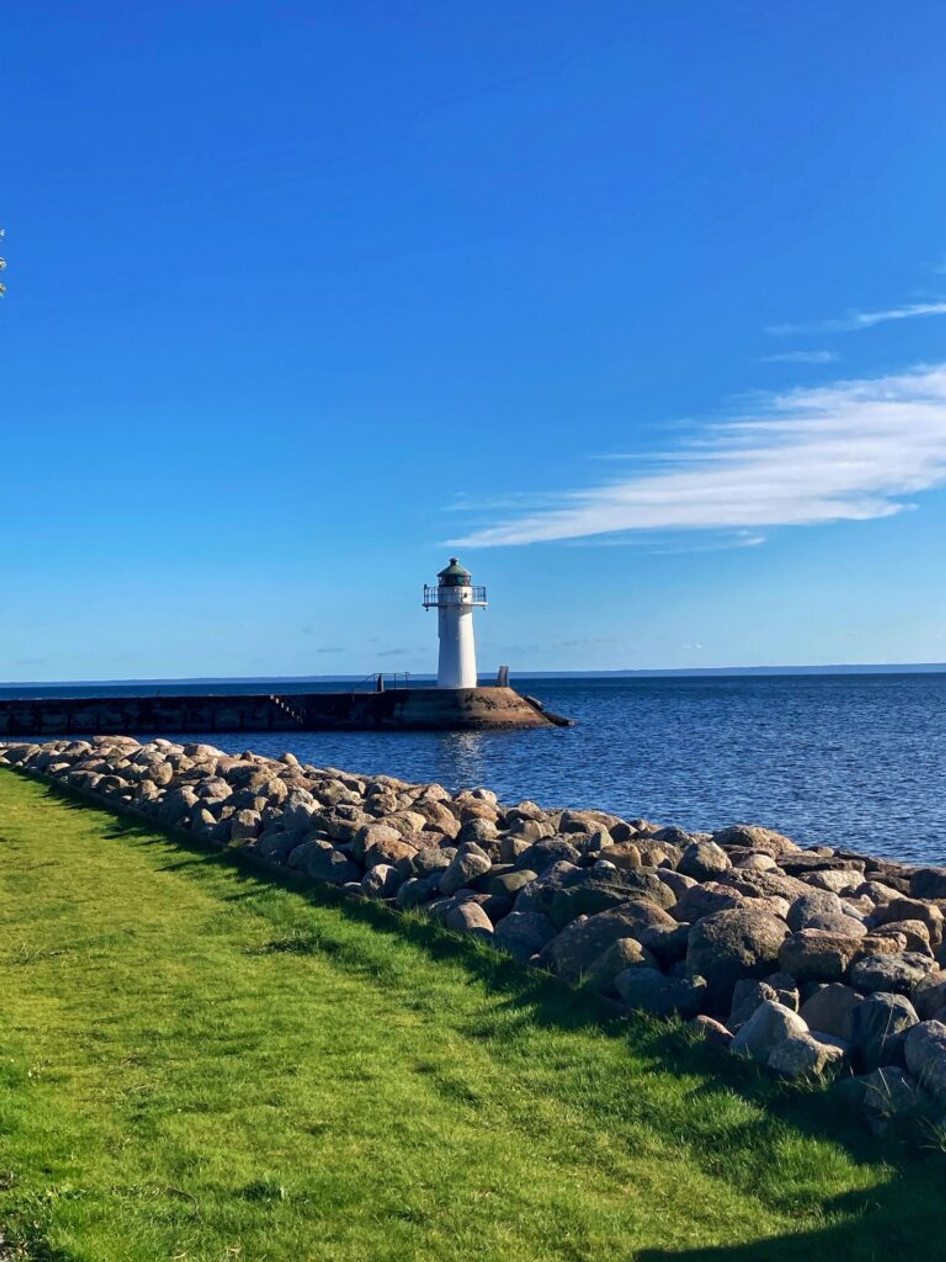 Scenic view of the coastline with a distant lighthouse.