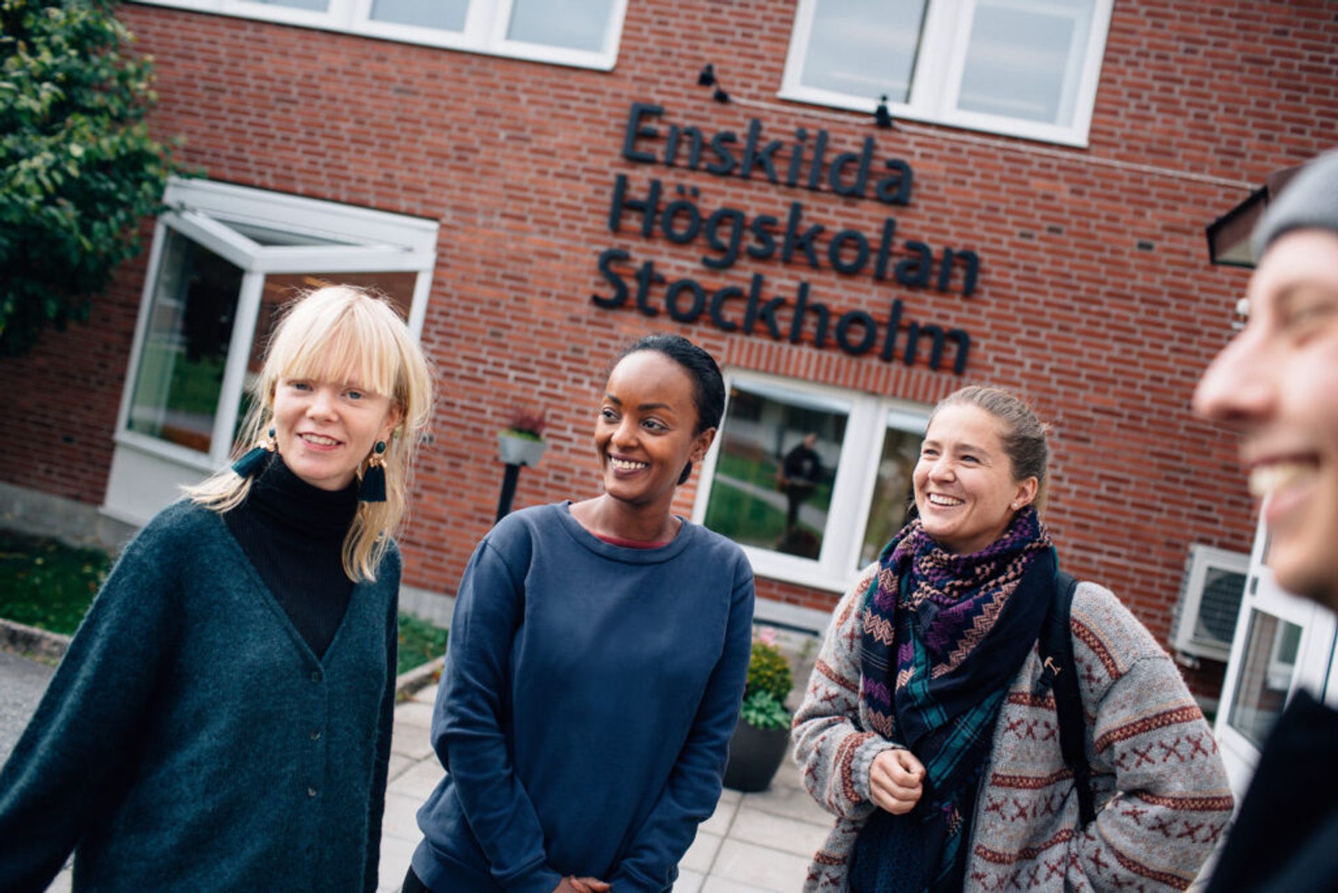 Students standing in front of a University College Stockholm campus building.