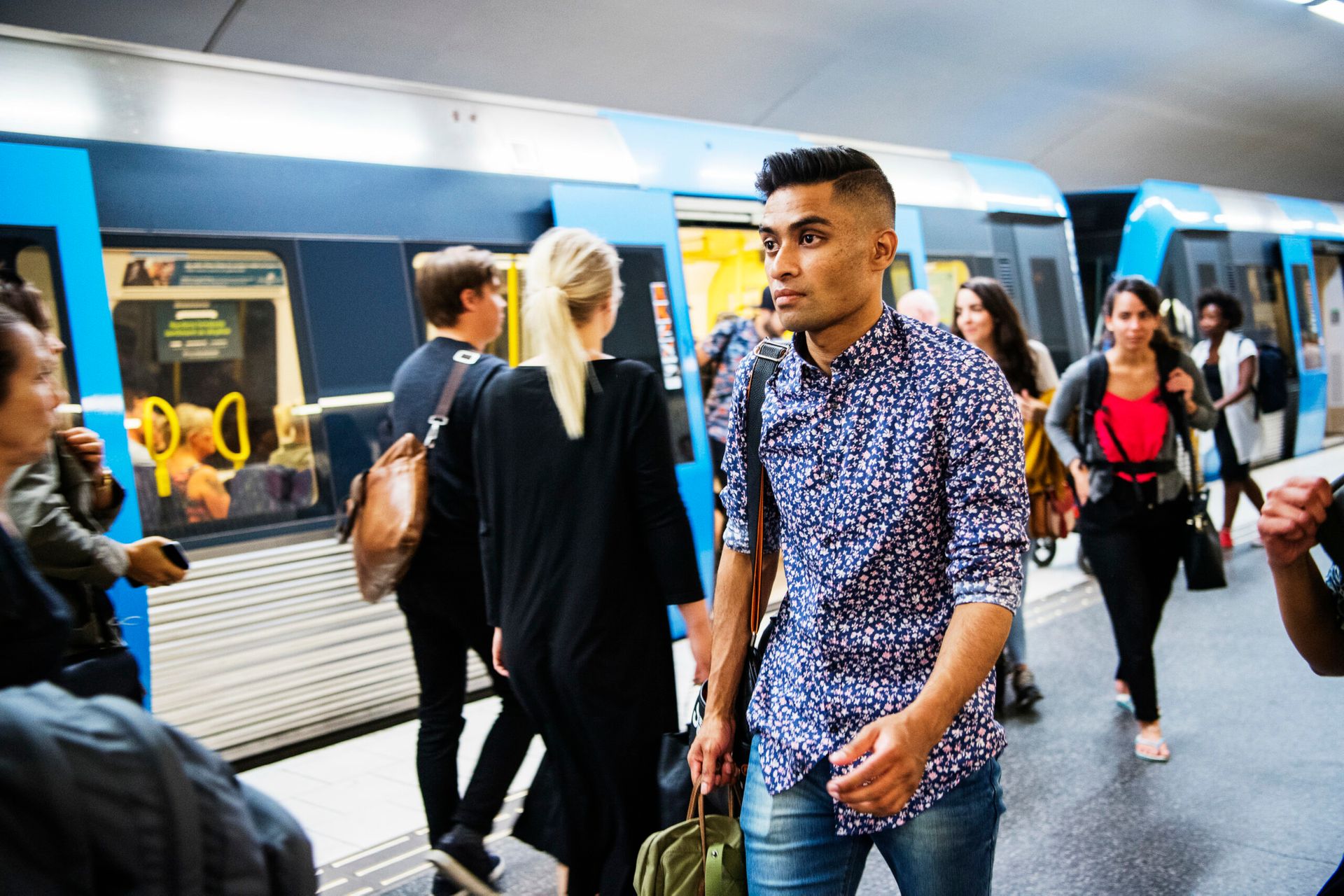 A man making his way through a crowded train station platform in Stockholm.