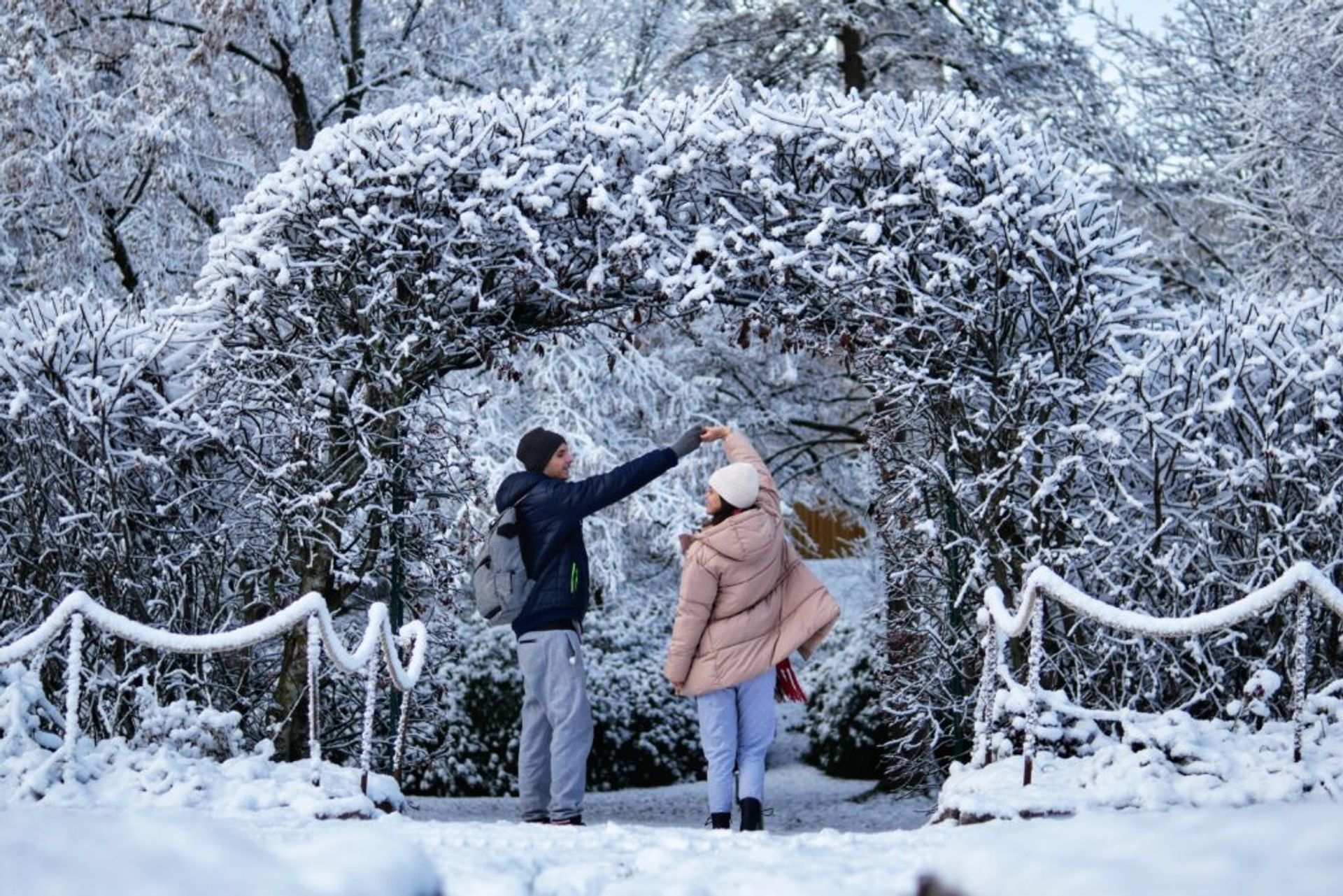 A girl and a boy dancing on a snow.