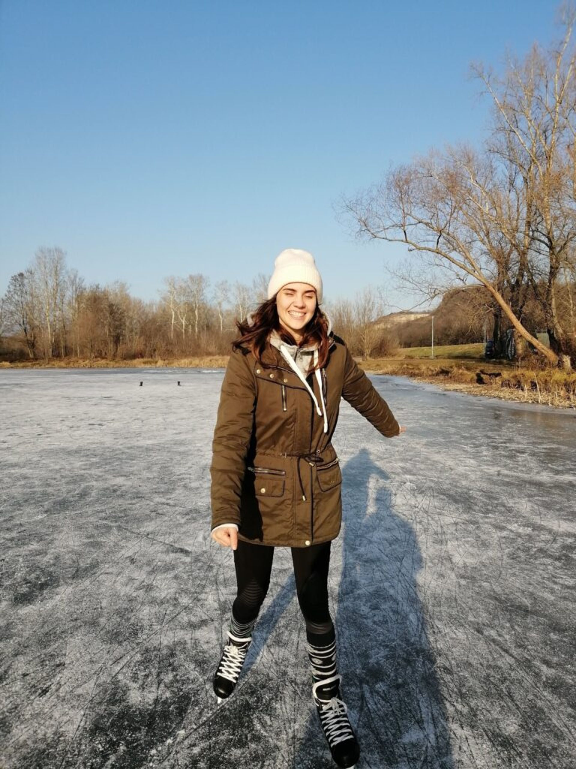 Girl laughing and ice-skating on a frozen lake. 