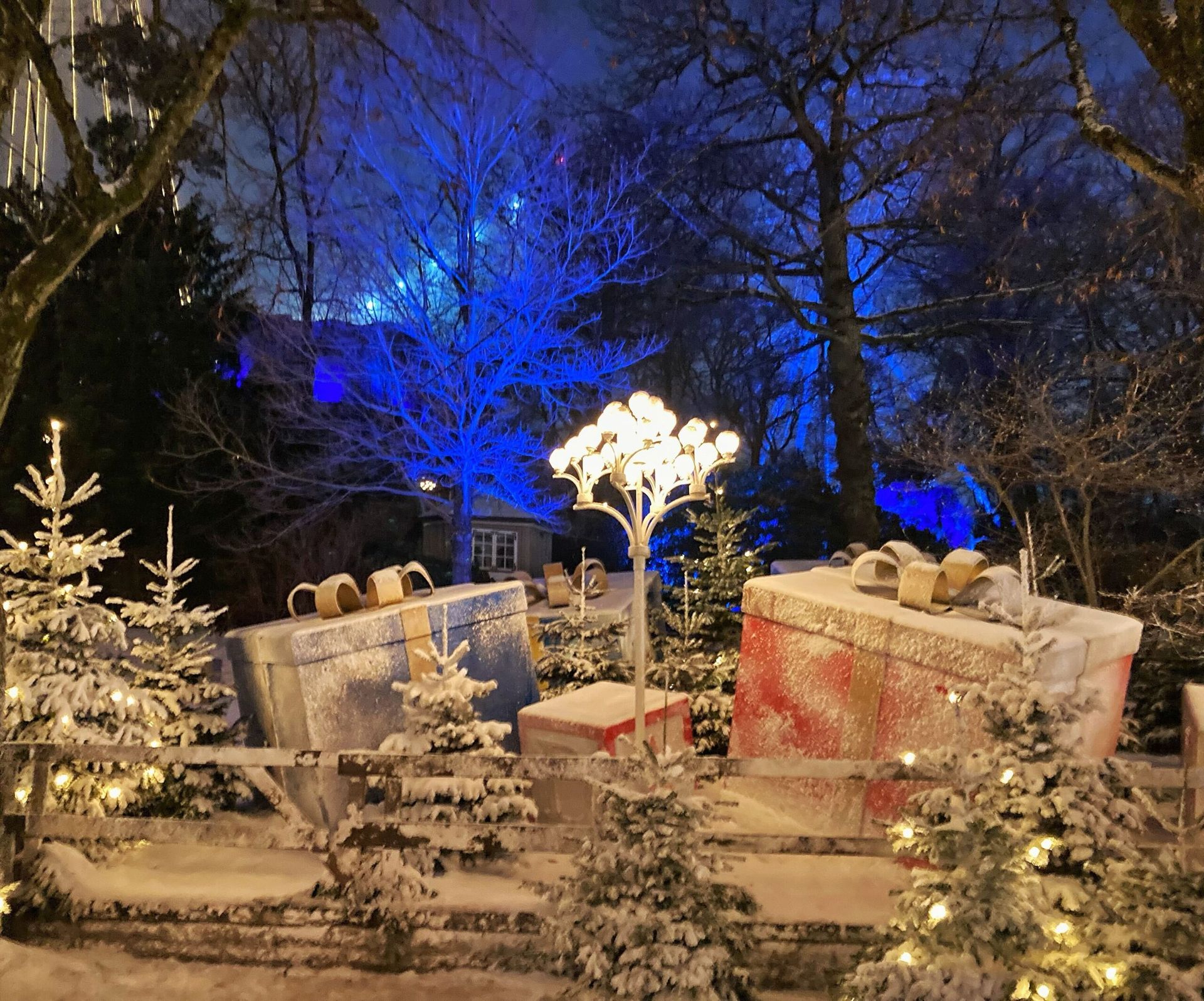 Outdoor decorations covered in snow, featuring oversized Christmas presents.