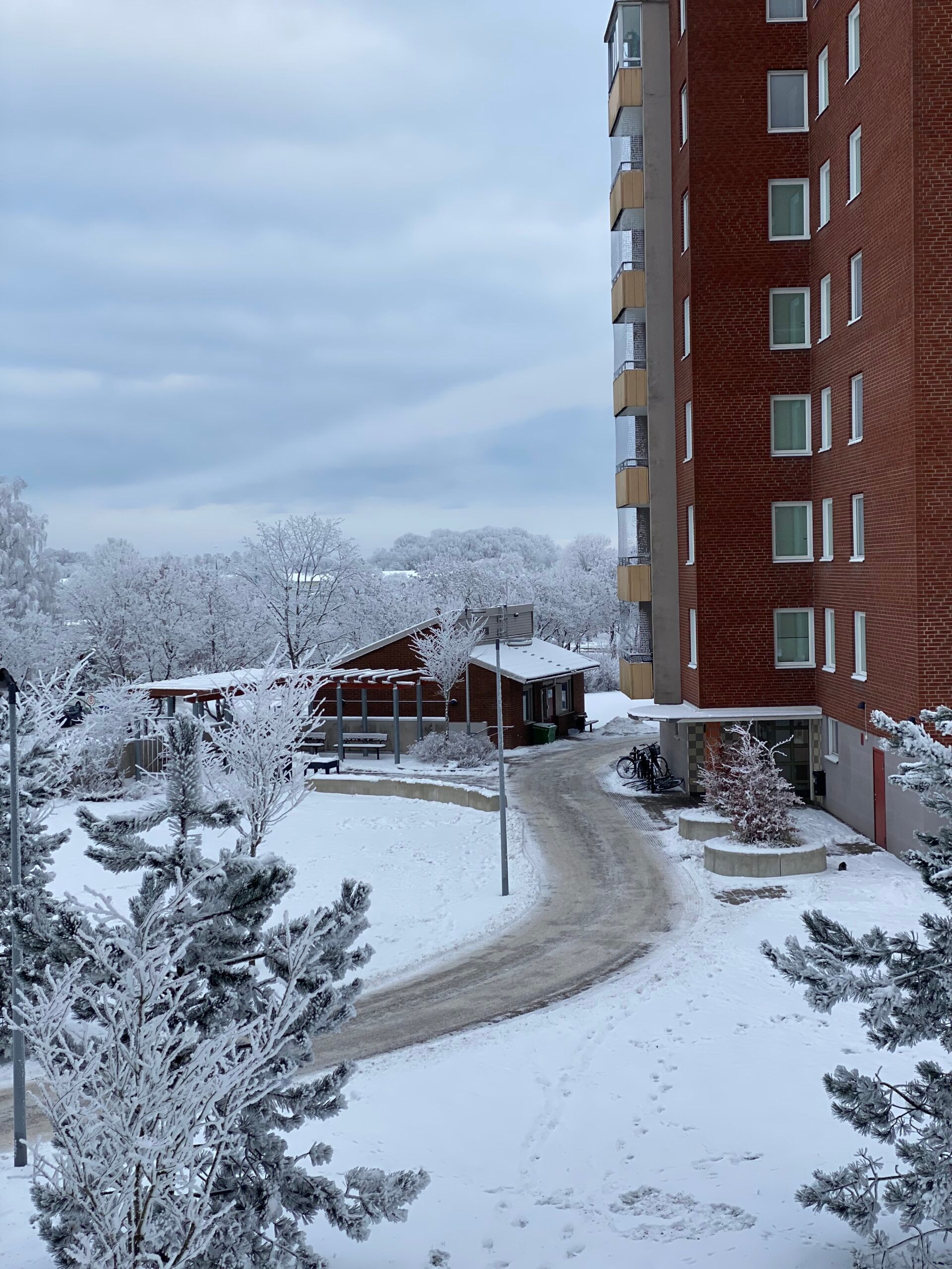 A view from an apartment window of a quiet neighbourhood after a snowy day.