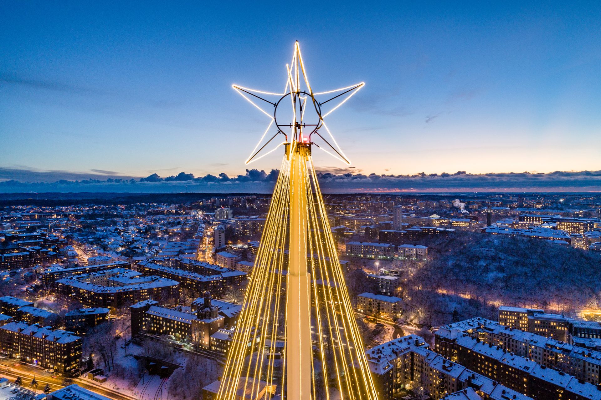 A Christmas star shining atop a light display, overlooking the cityscape of Gothenburg.