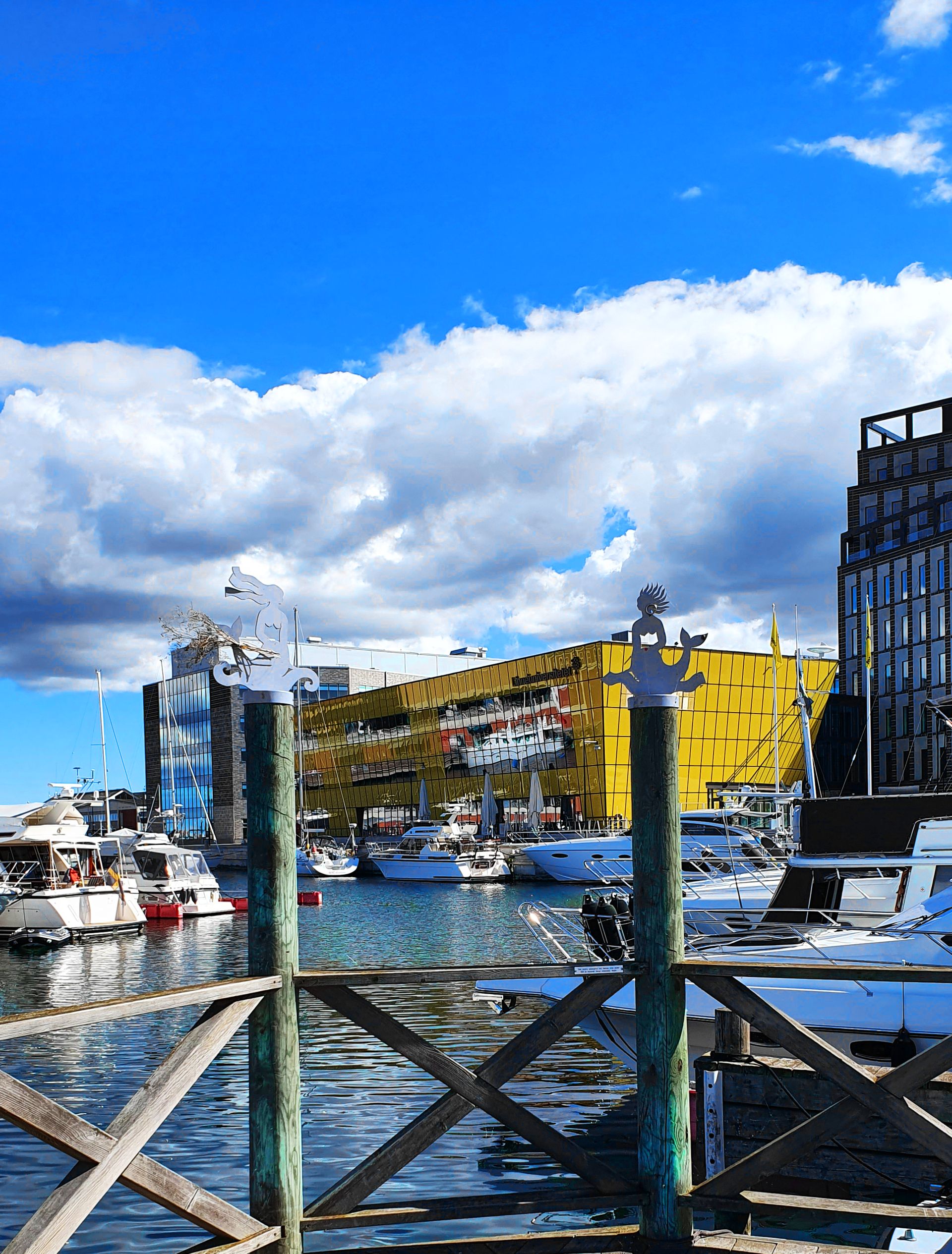 A harbour with several boats docked and buildings close by.