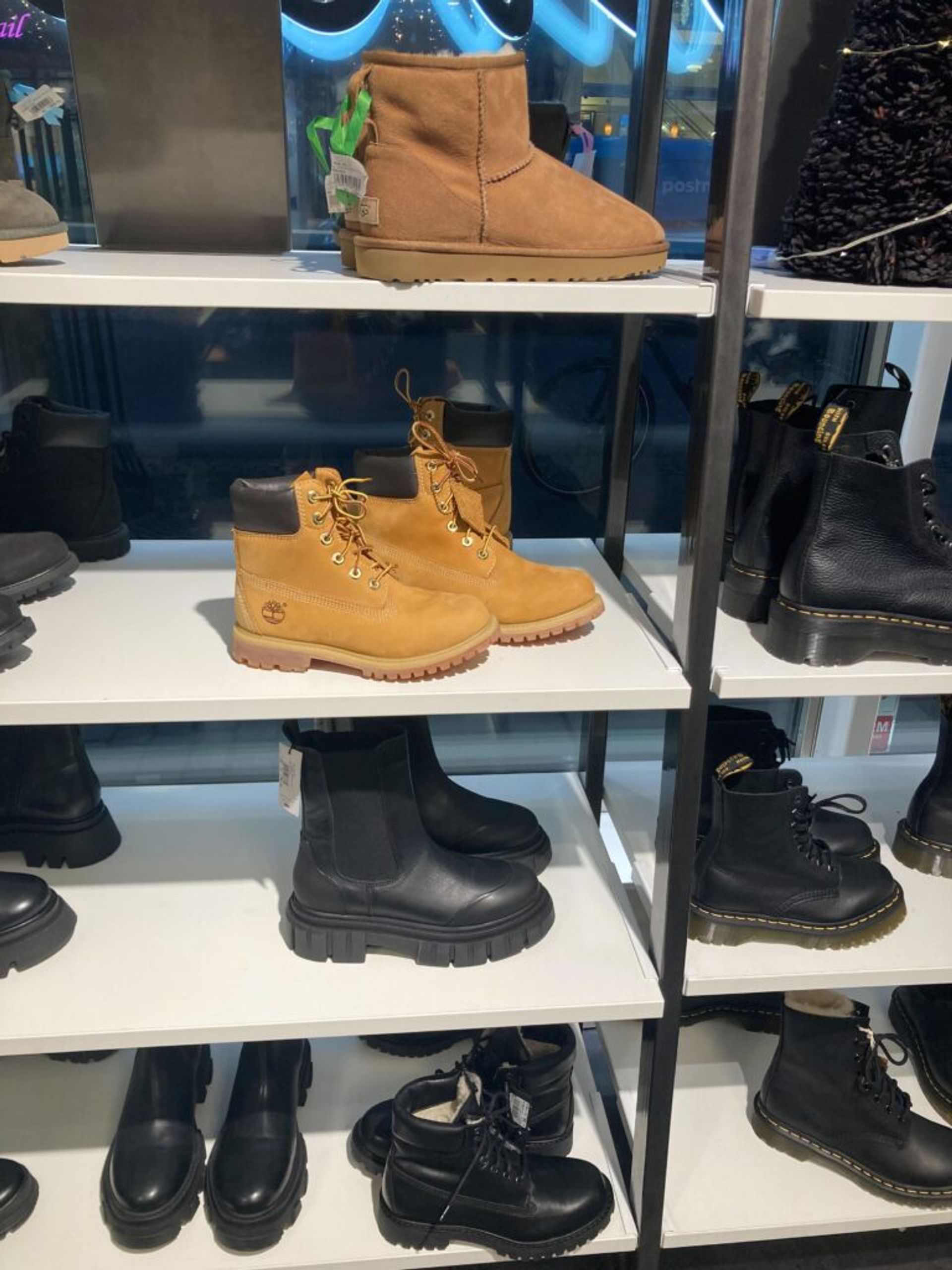 An array of winter boots on display in a clothing store.