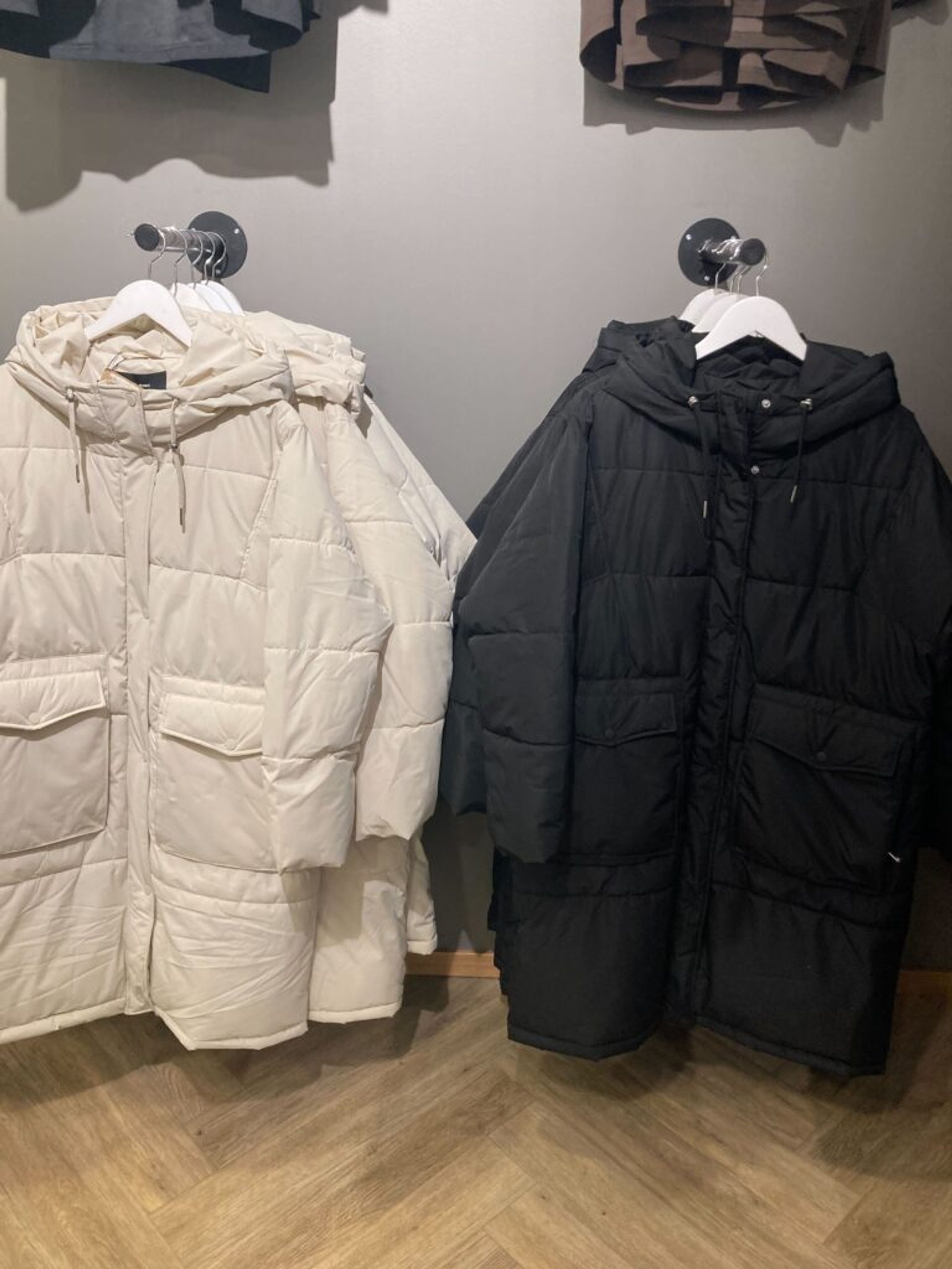 Black and white winter jackets on display in a clothing store.