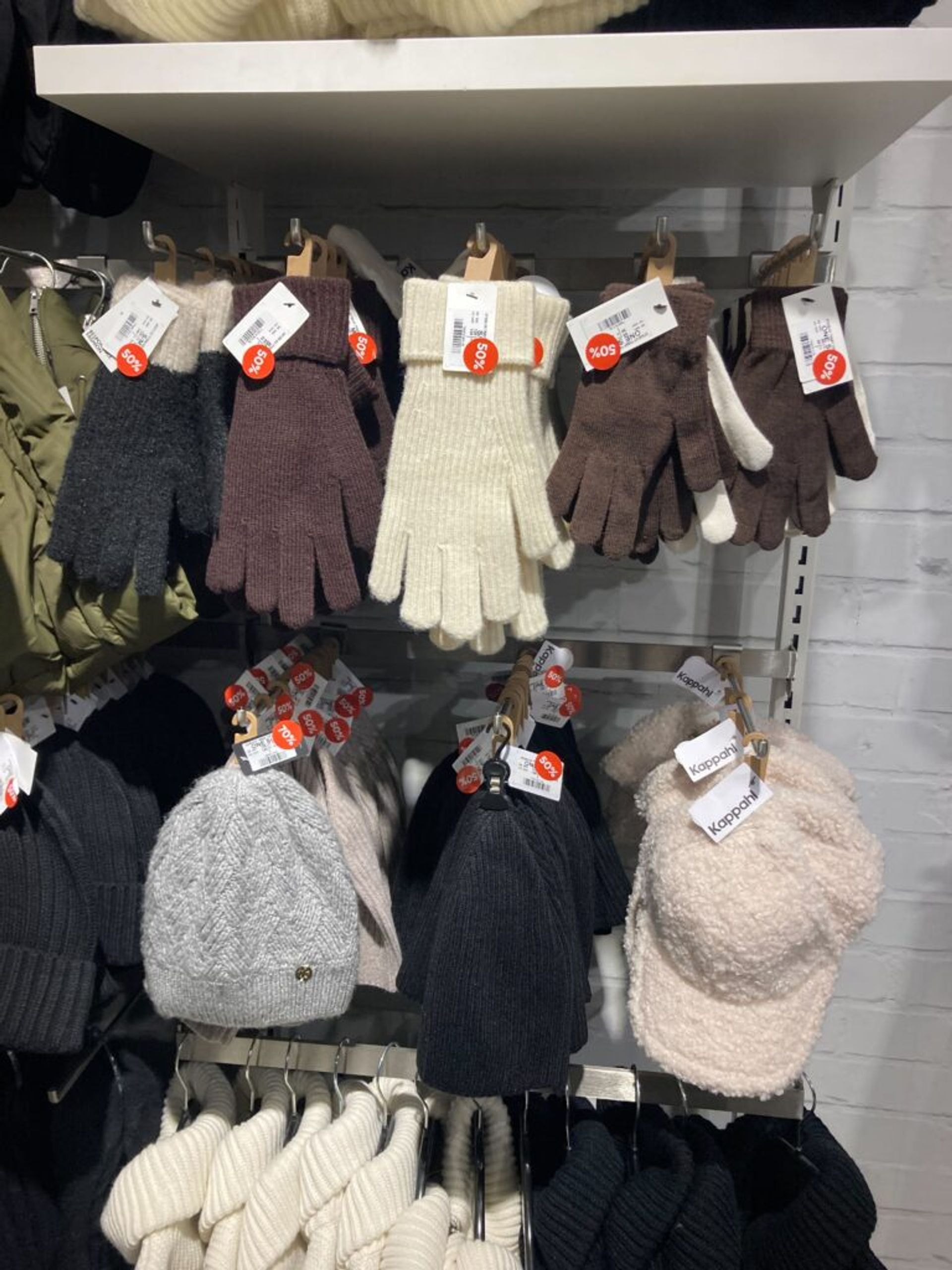 Gloves and hats on display in a clothing store.