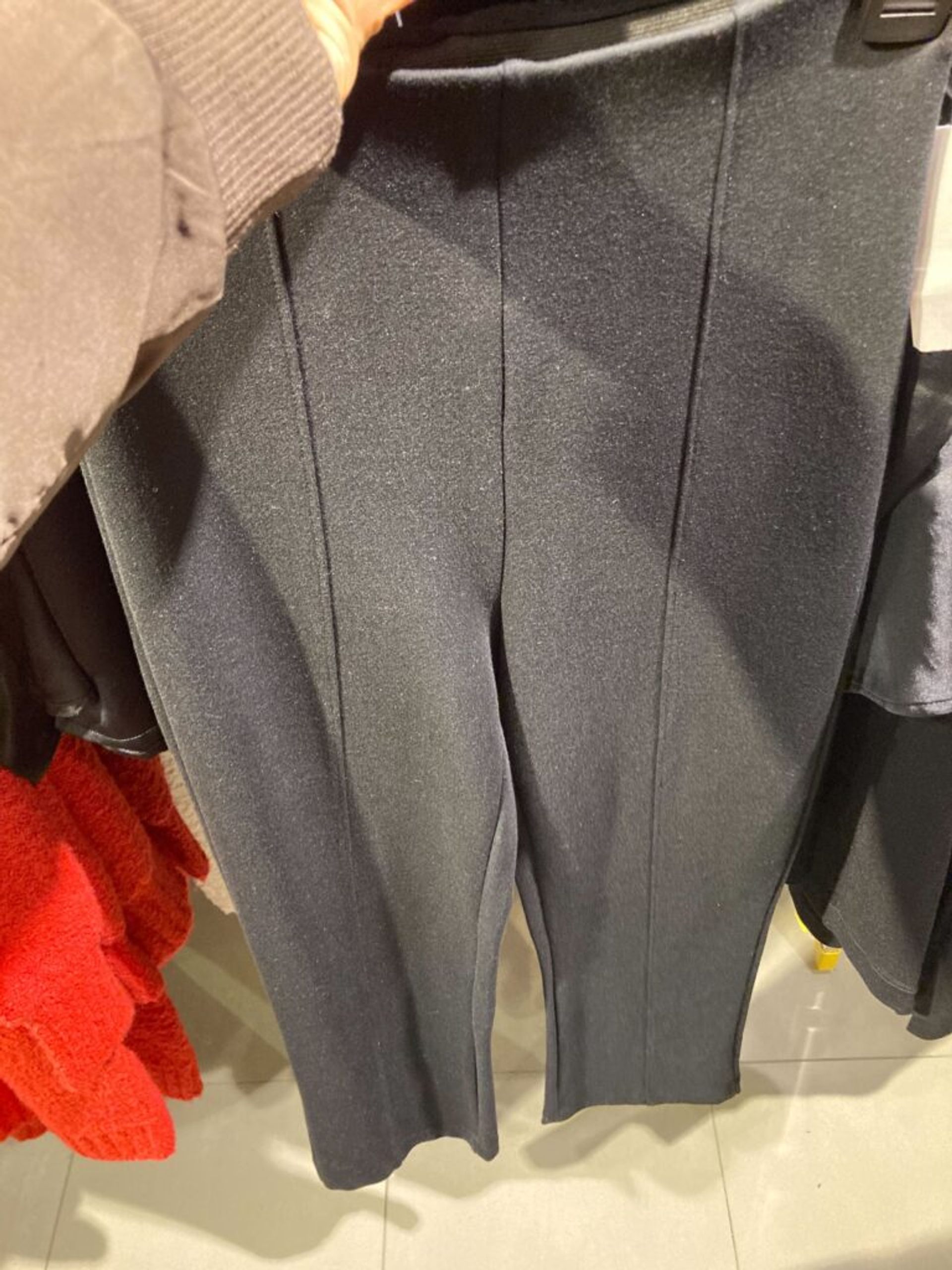 Black pants on display in a clothing store.