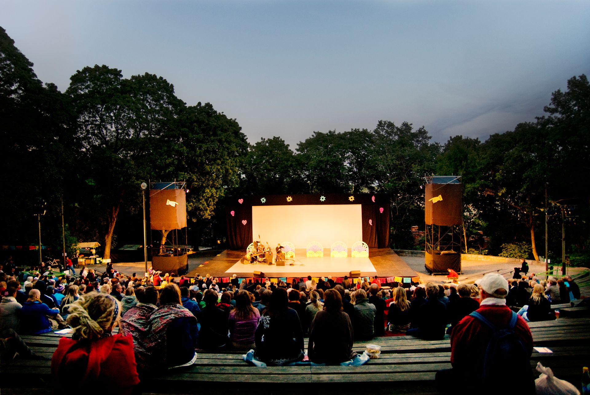 The audience is watching a theatre performance outdoors in Stockholm.