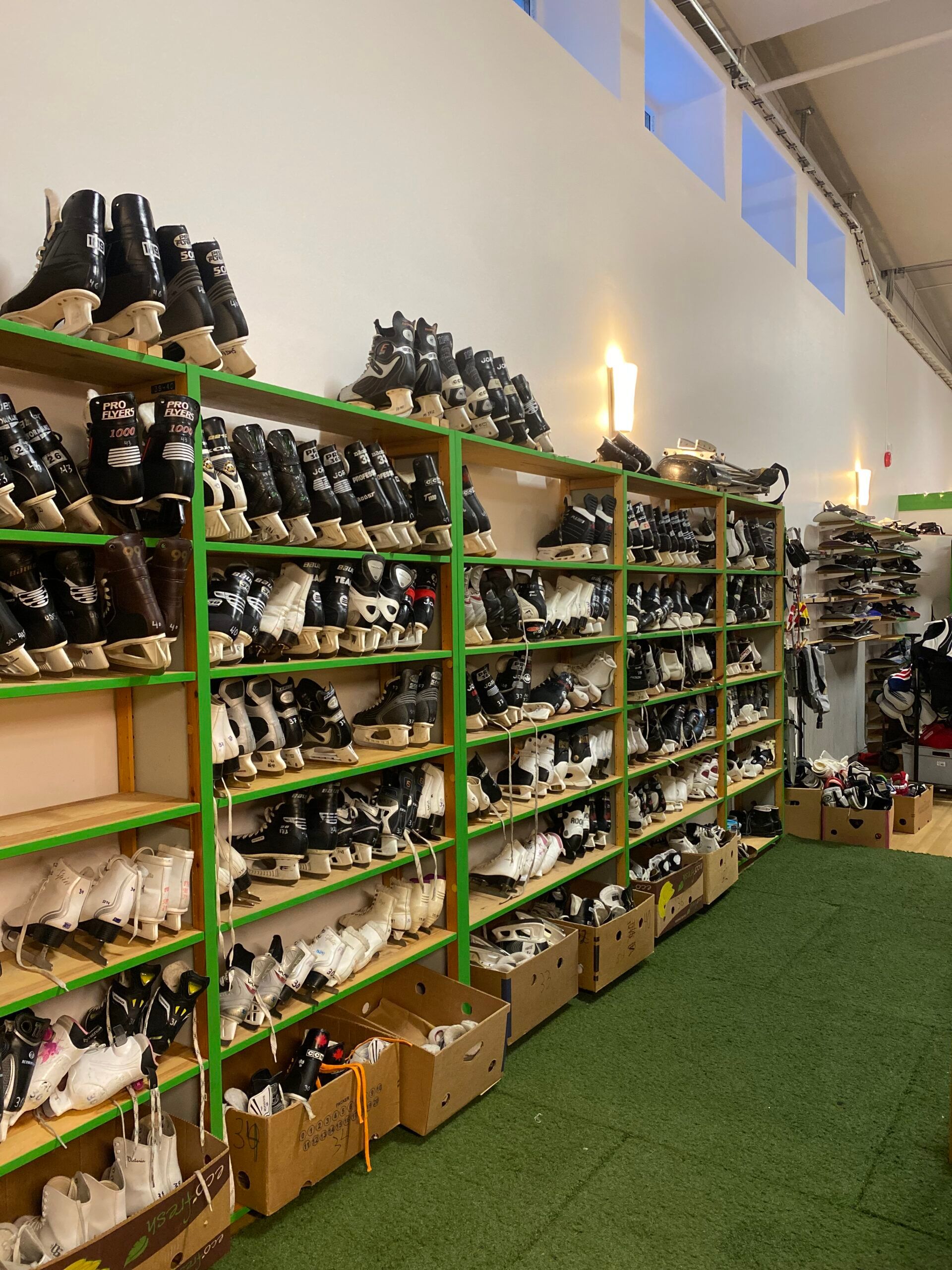 Shelves at Fritidsbanken display a selection of ice and hockey skates.