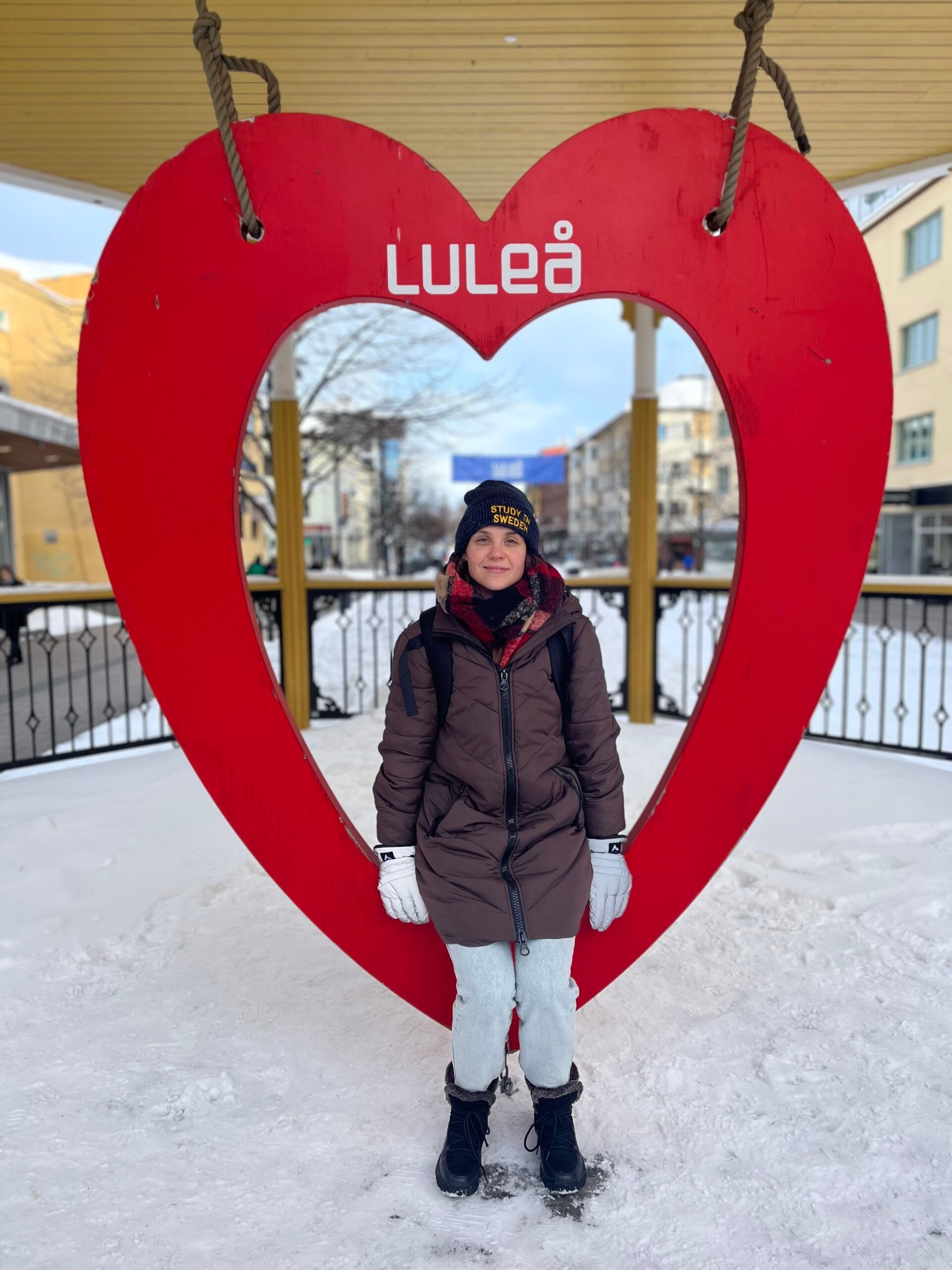 A girl sitting in a heart with Lulea sign.