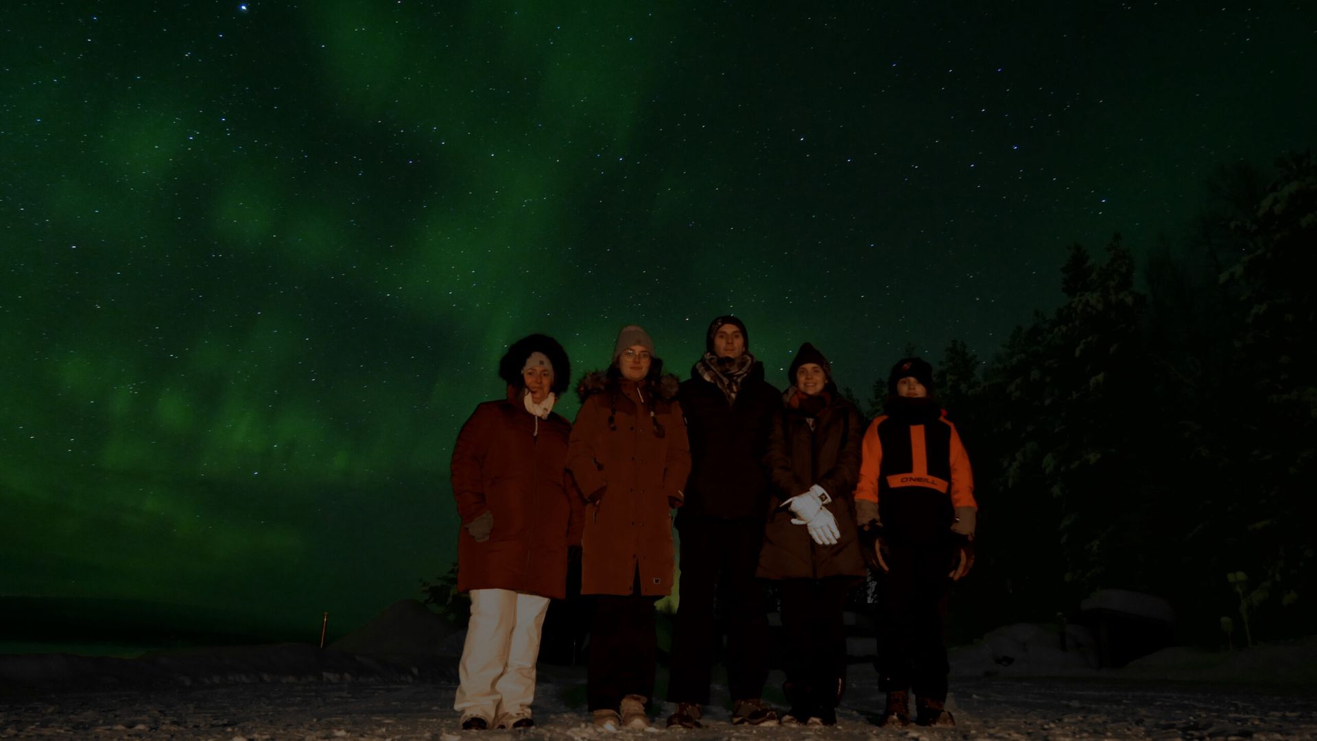 People with Northern lights in the background. 