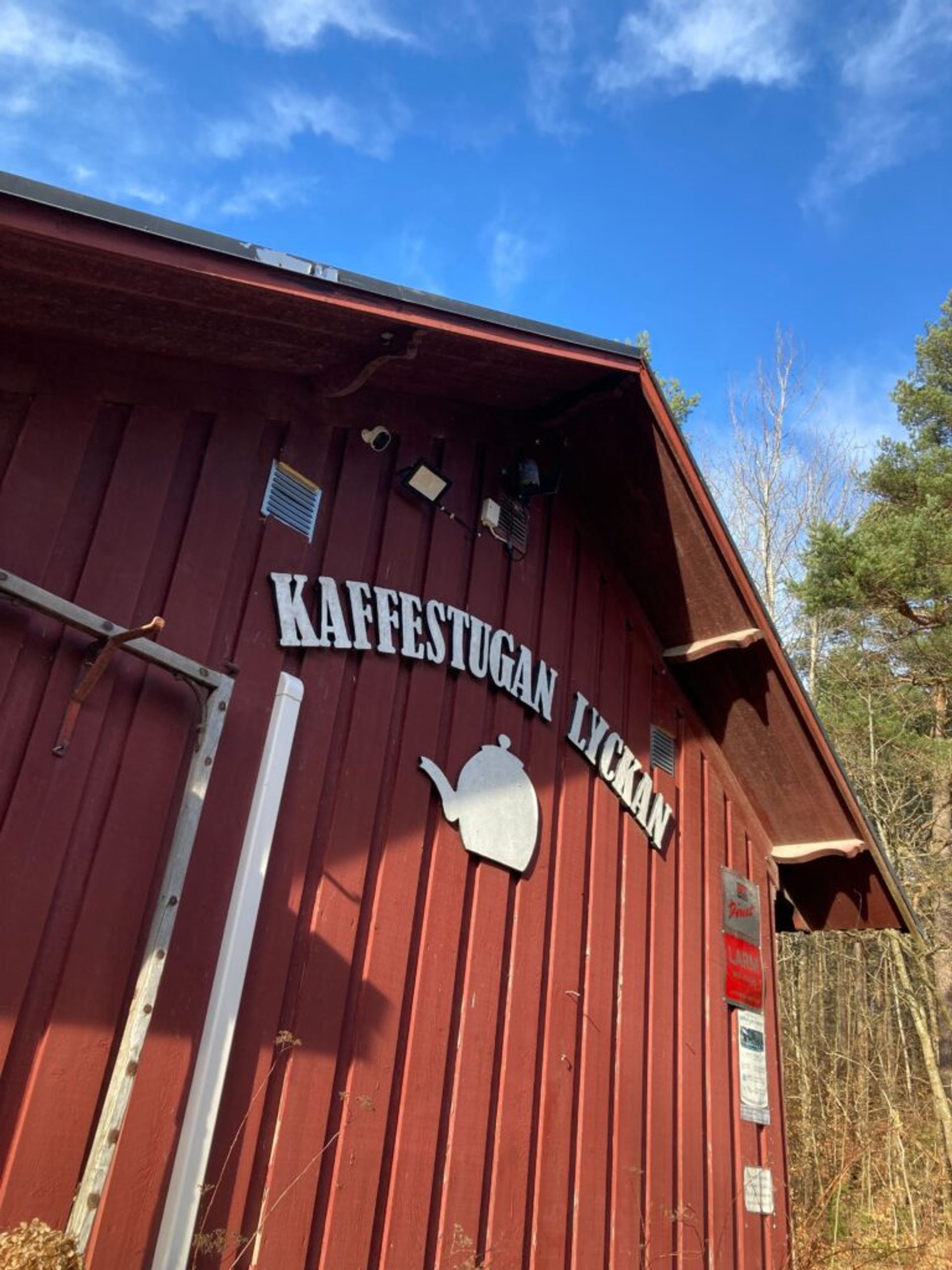 A traditional Swedish-style building featuring a café logo.