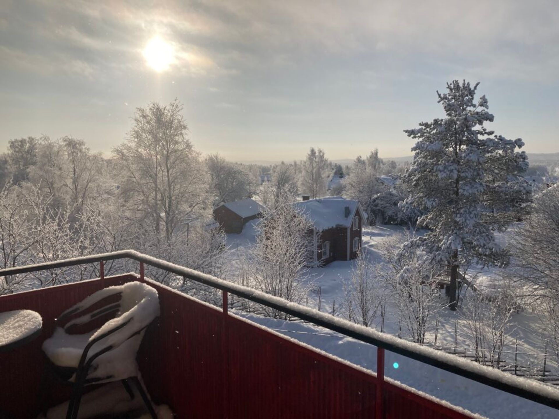 A snowy landscape viewed from a balcony.